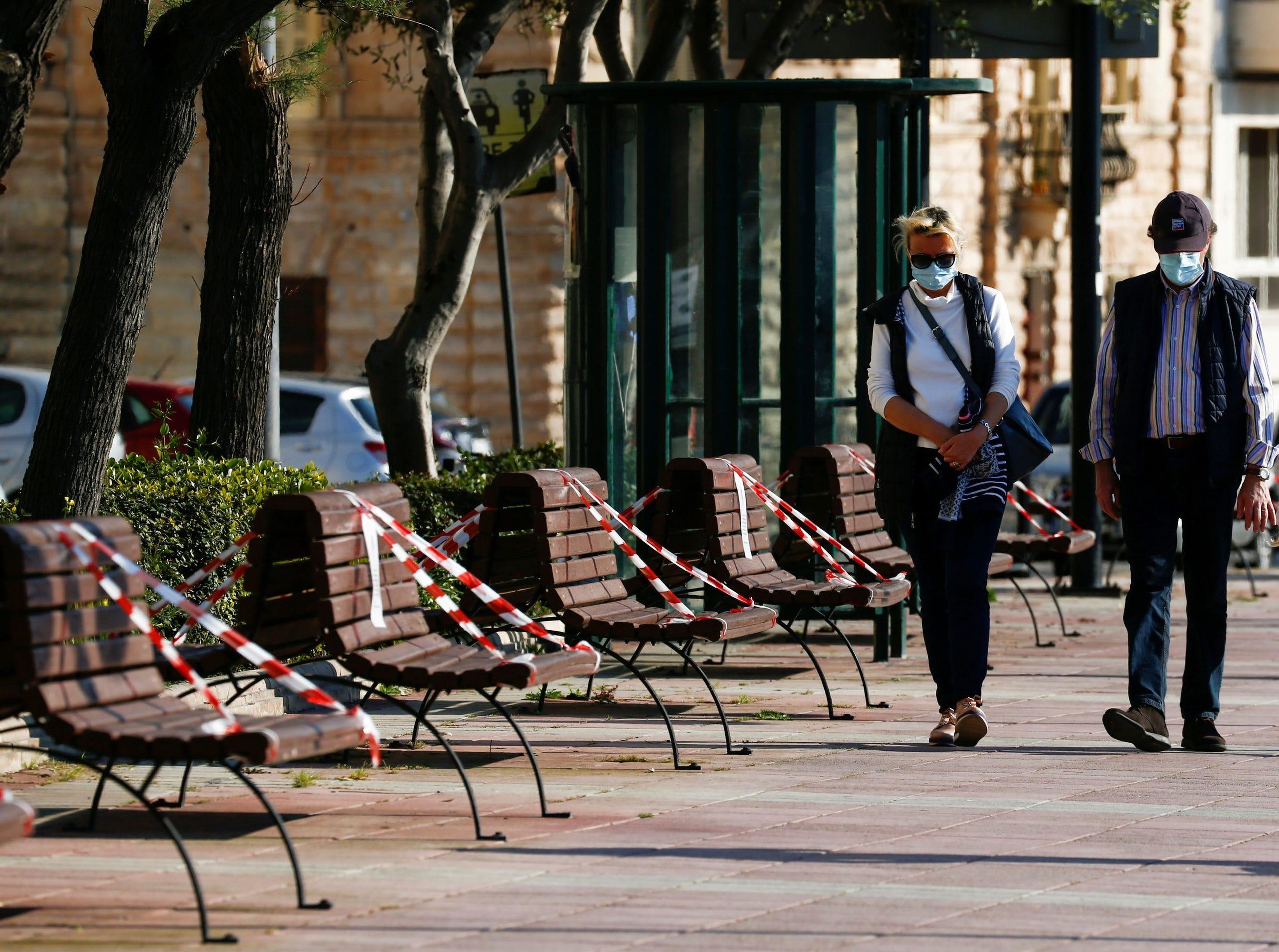 Un hombre y una mujer pasean con mascarilla por Malta, abril de 2020.