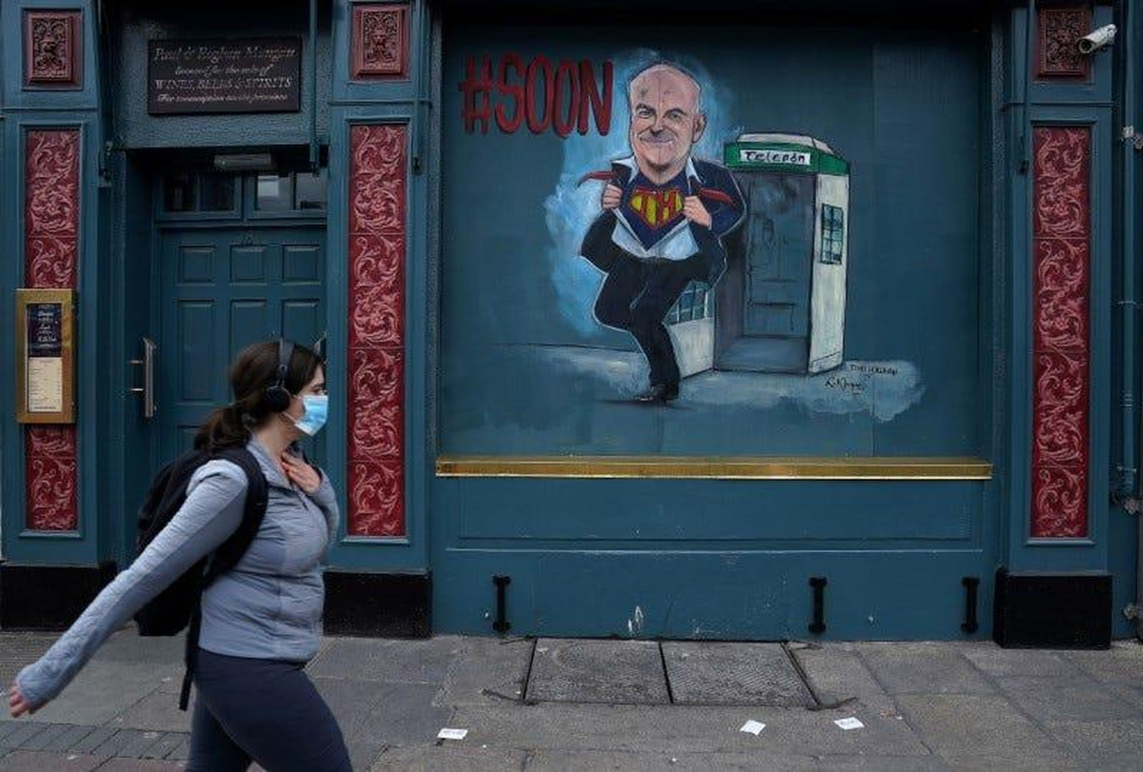 Una mujer pasea frente a una caricatura del director médico de Salud de Irlanda, Tony Holohan, en Dublín, Irlanda, el 15 de mayo de 2020.
