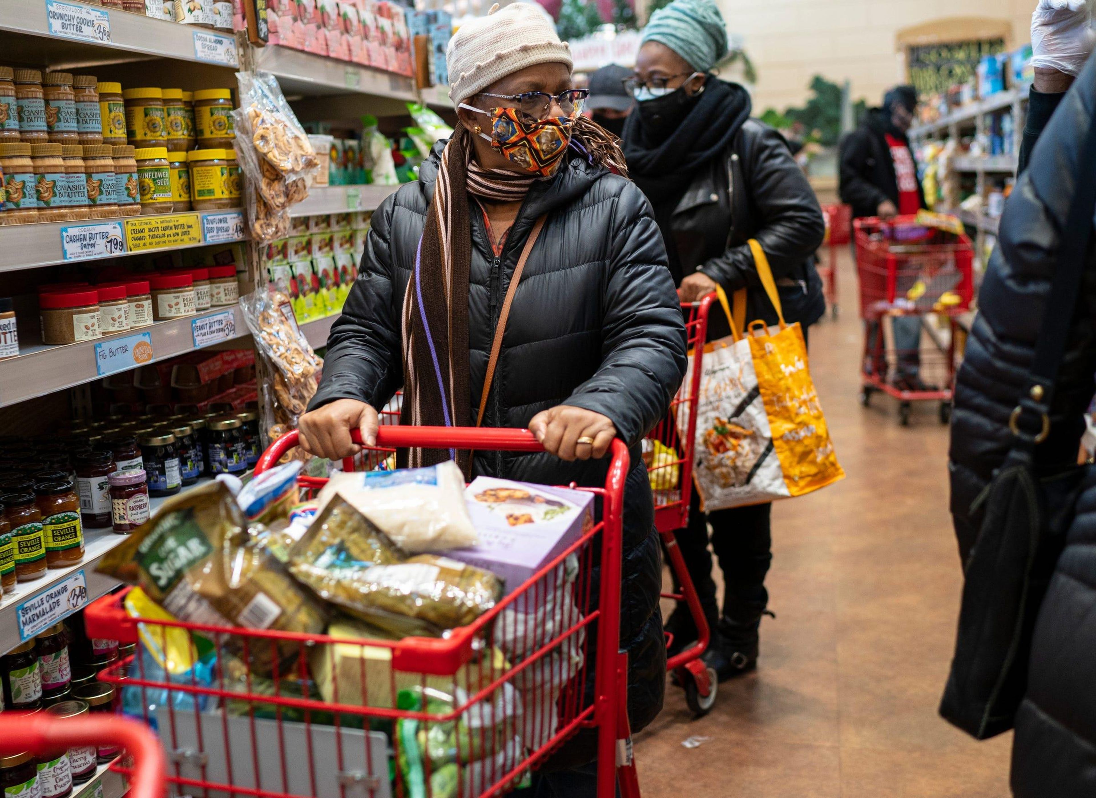 A woman wearing a mask moves her shopping cart in a Trader Joe's supermarket in New York City, December 3, 2020.