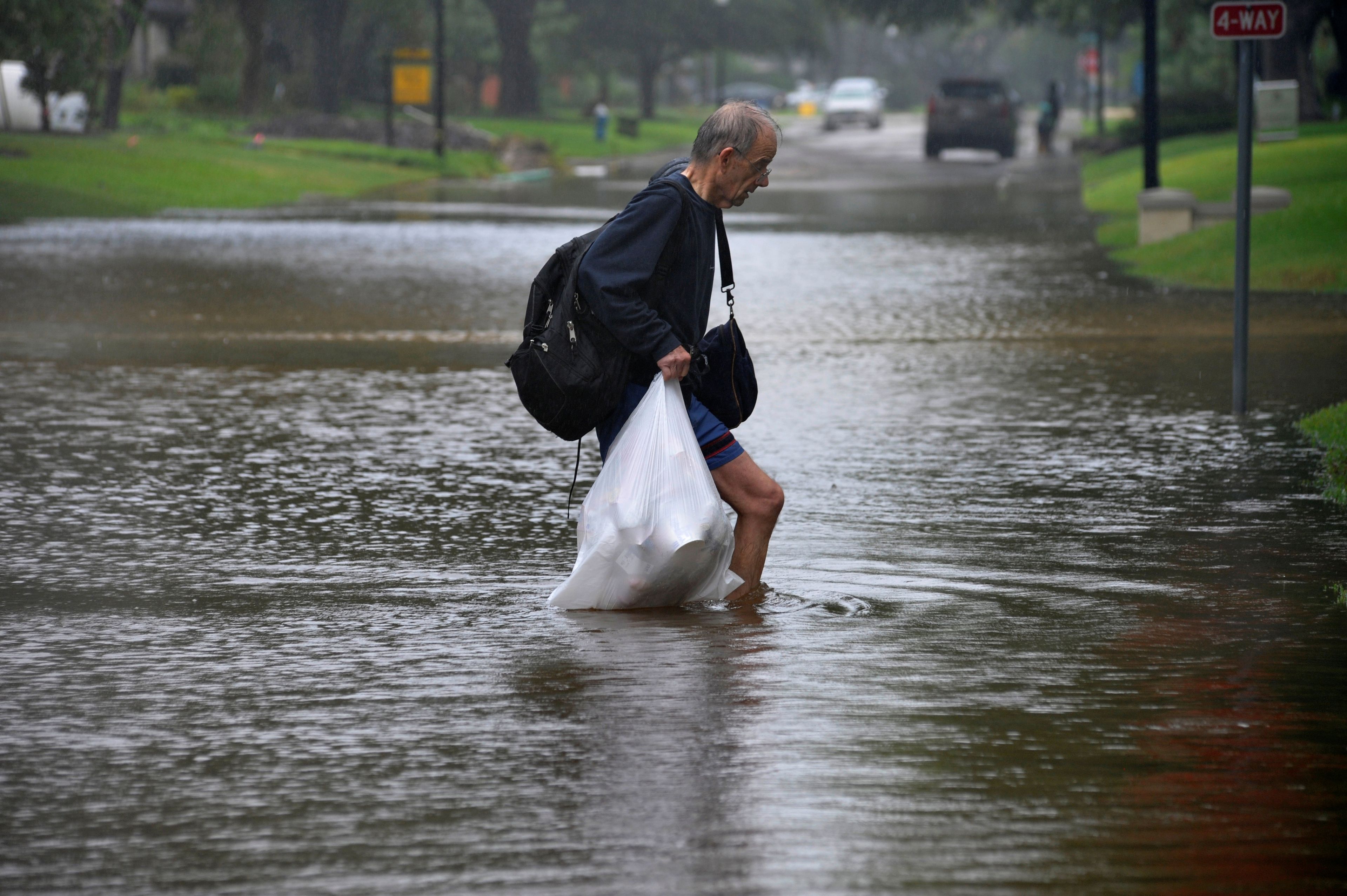 Un hombre carga con sus pertenencias durante las inundaciones de 2017 en Texas (Estados Unidos) provocadas por el huracán Harvey.