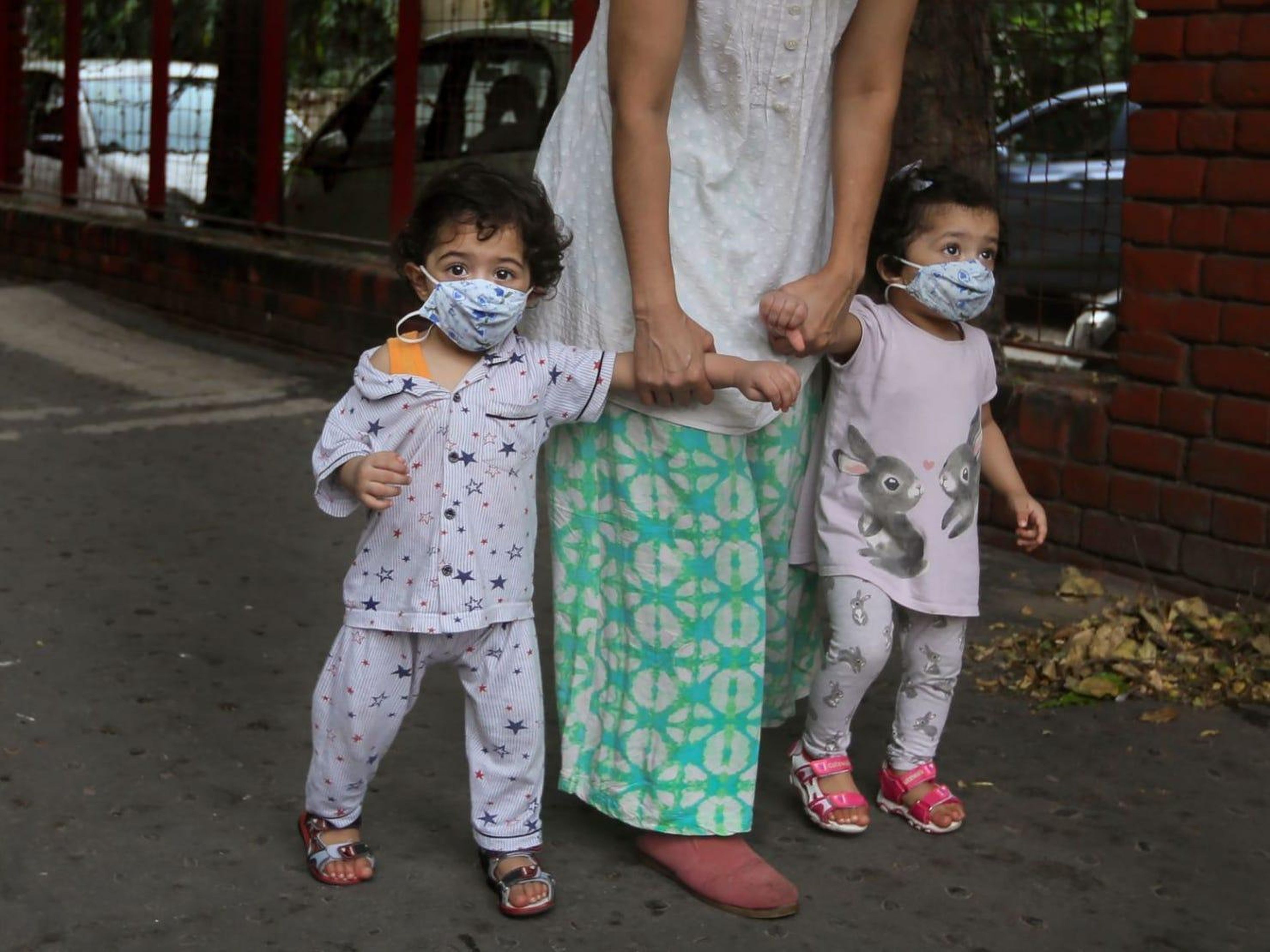 Una mujer lleva a sus niños pequeños a caminar con máscaras, en Nueva Delhi, India, el 26 de agosto de 2020.