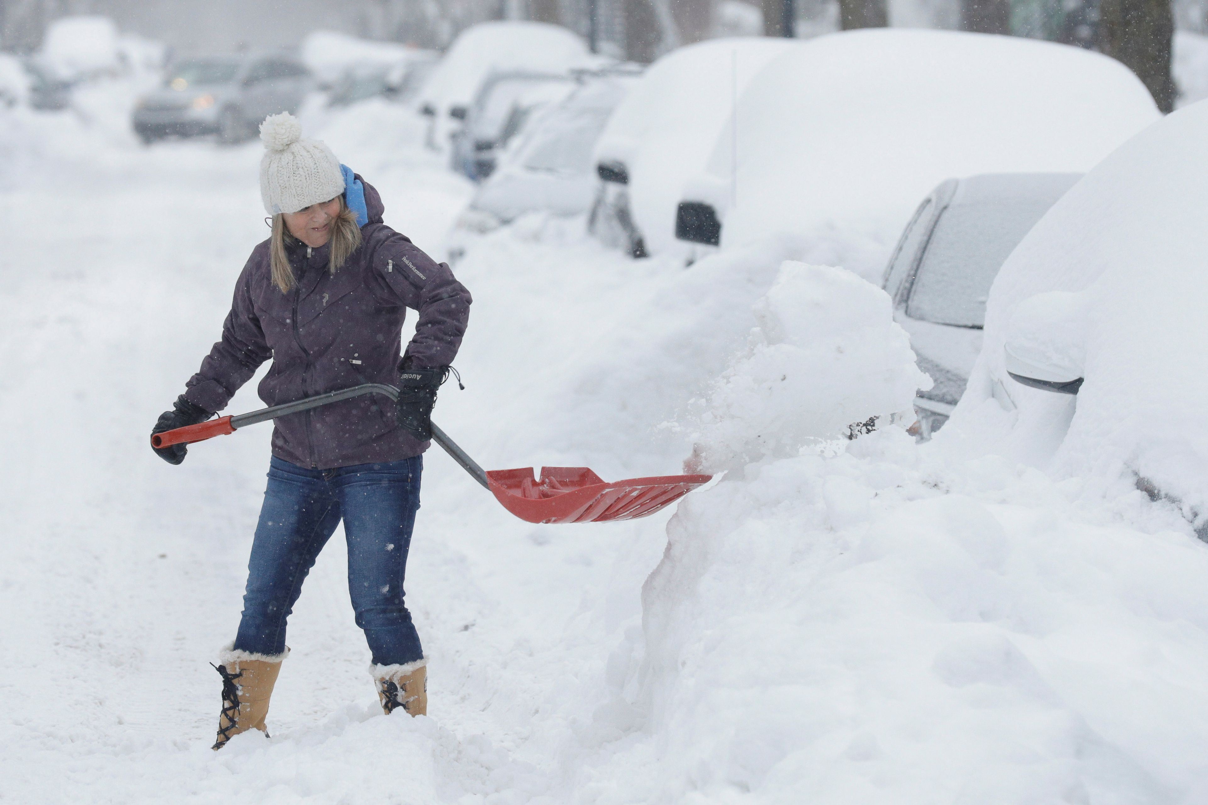 mujer retirando nieve coche