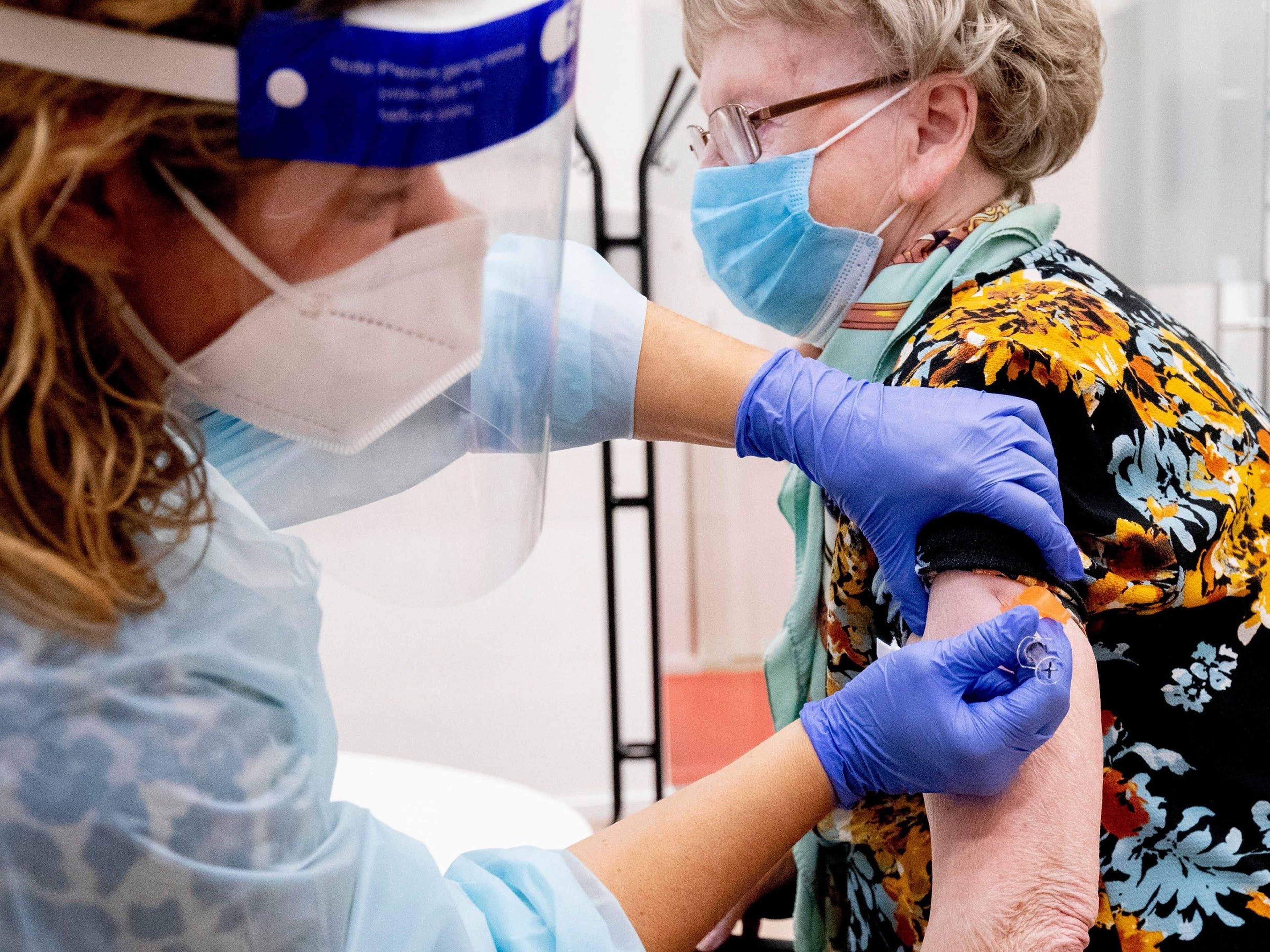 Un trabajador sanitario administra a una señora mayor una vacuna contra la gripe en Zoetermeer, Países Bajos.