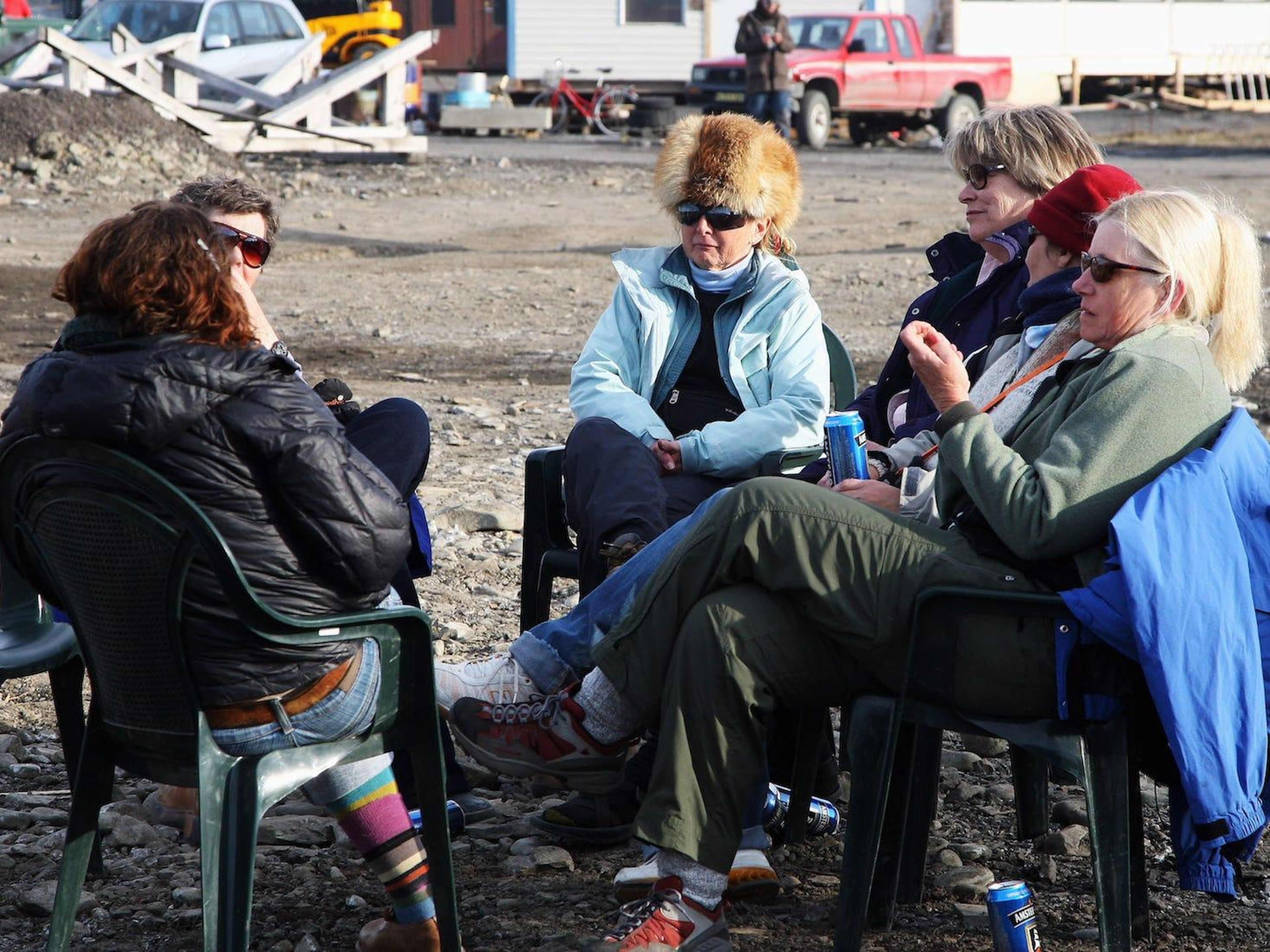 Gente relajándose junto a una hoguera celebrando el solsticio de verano en Longyearbyen.