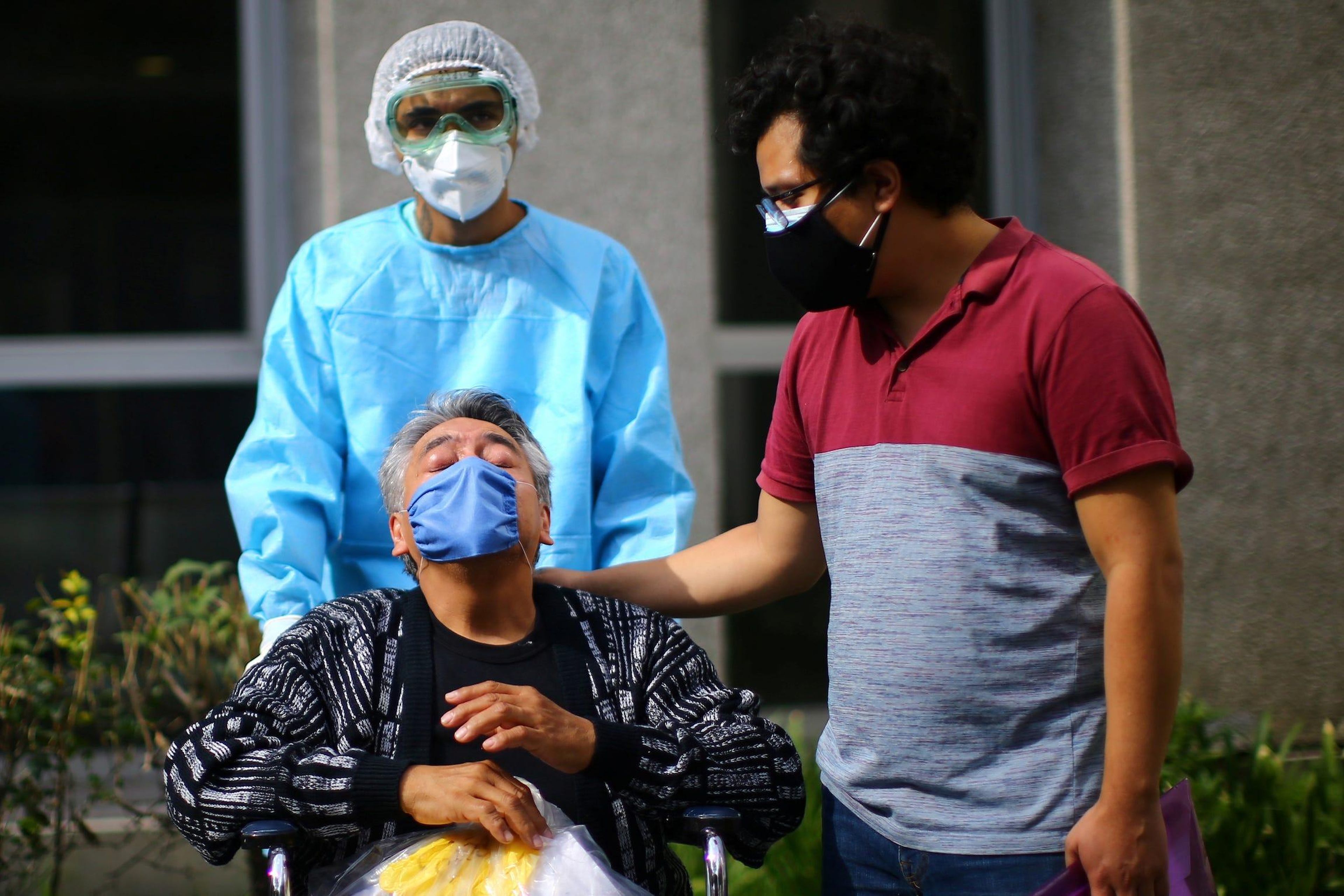 Rufino, a patient who has recovered from the coronavirus disease (COVID-19), gestures next to his son as he leaves from the Juarez Hospital to go to his house in Mexico City, Mexico, July 27, 2020. Edgard Garrido/Reuters