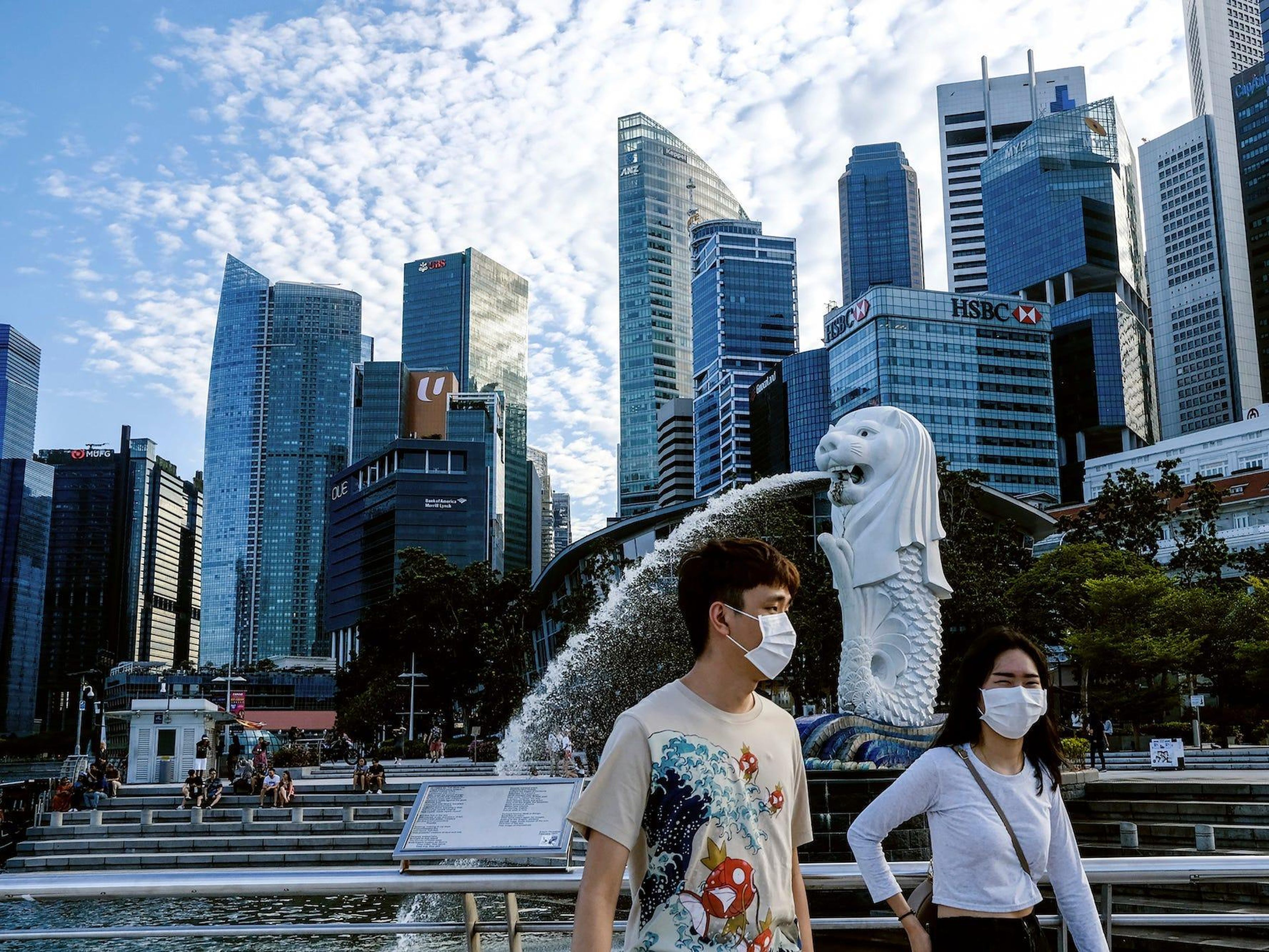 Una pareja con mascarillas camina por Singapur, 14 de marzo de 2020.