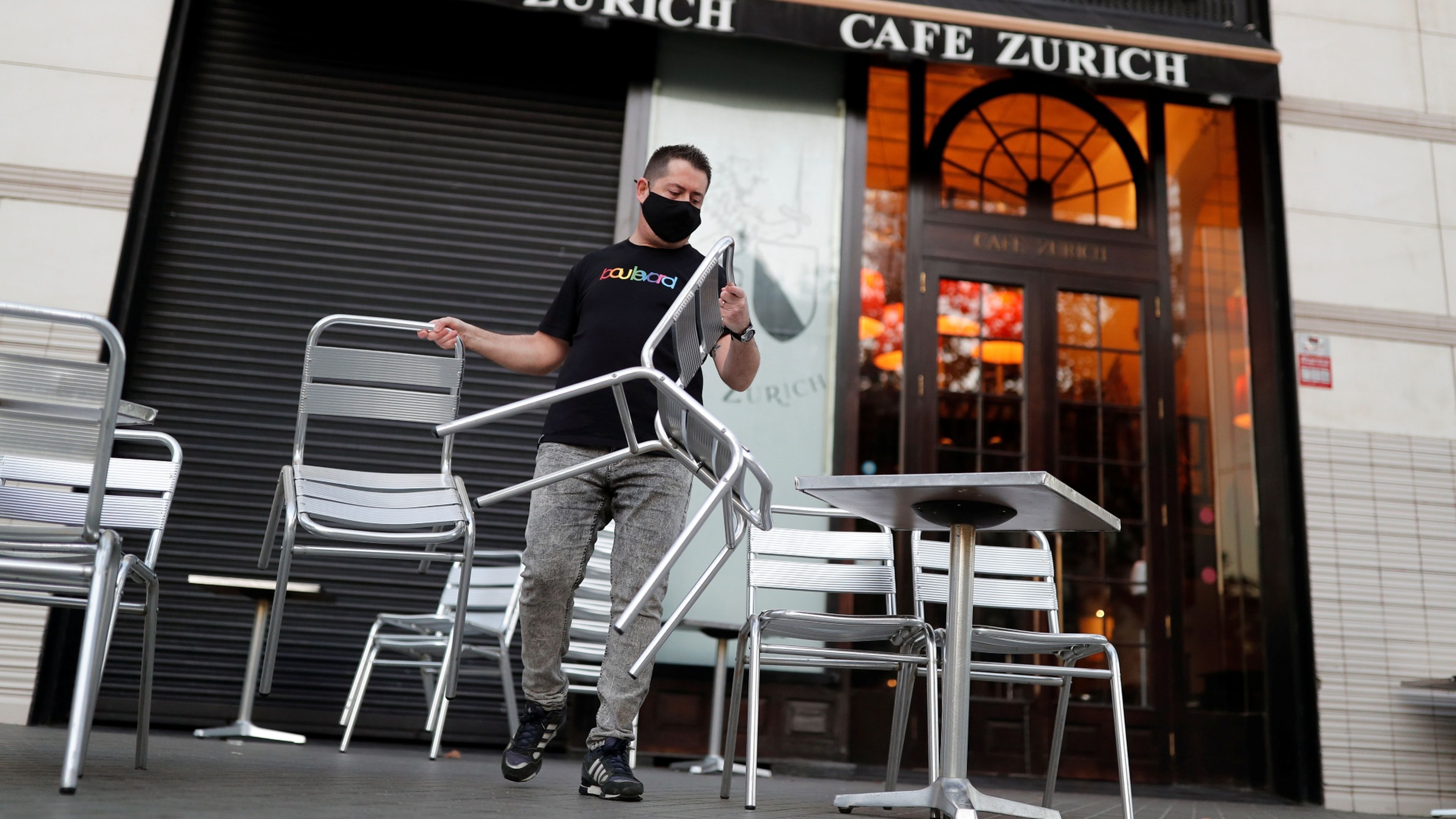 Un trabajador de una cafetería de Barcelona coloca las mesas de la terraza
