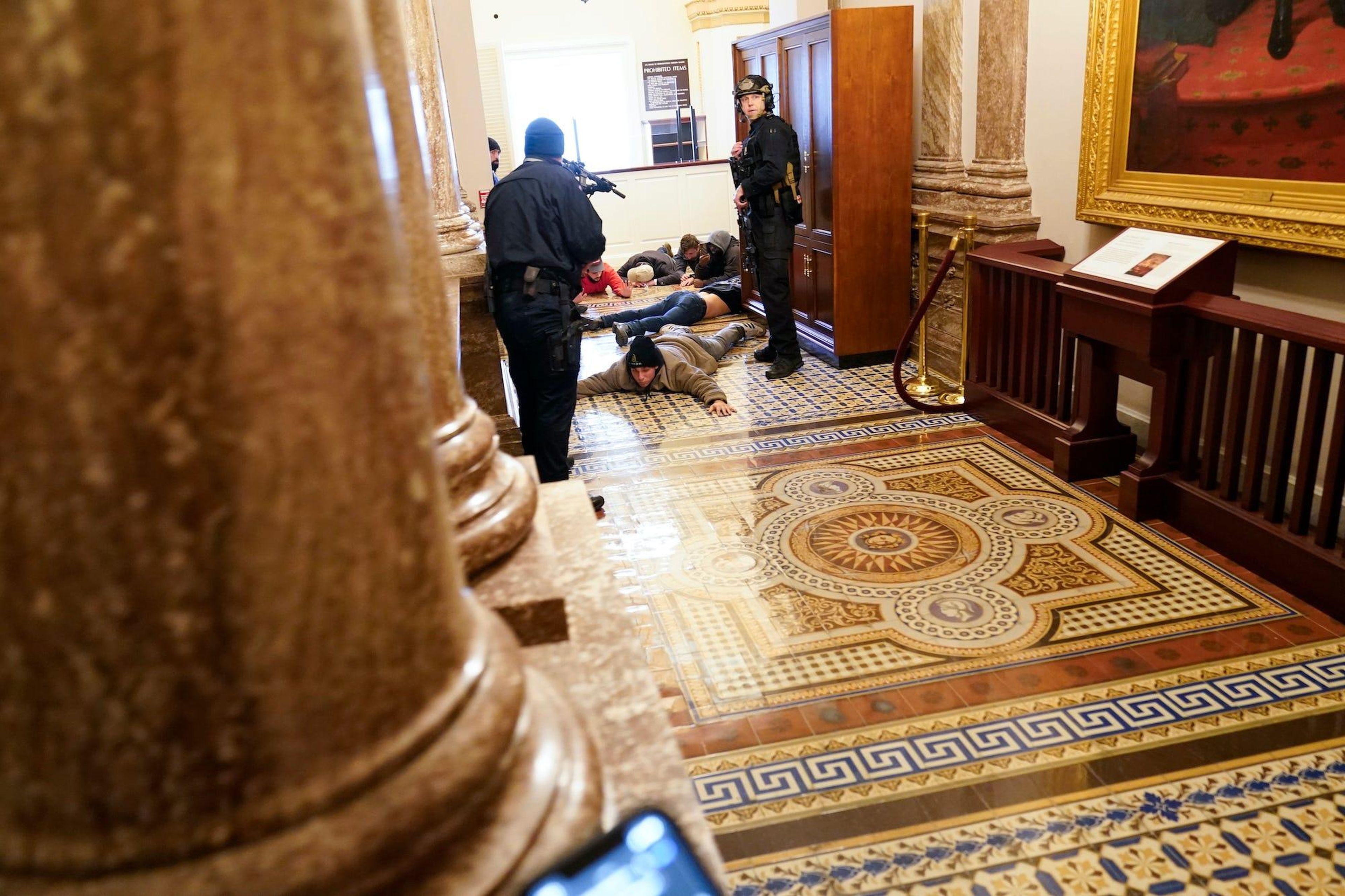 U.S. Capitol Police hold protesters at gun-point near the House Chamber.