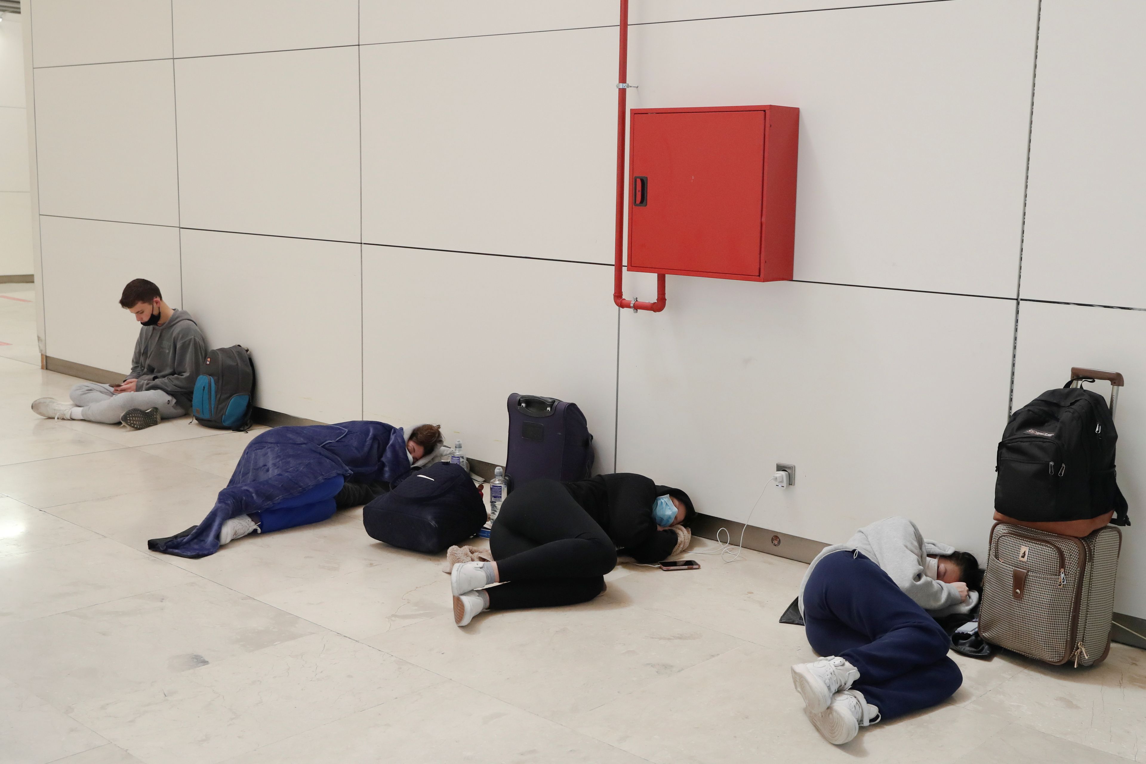 Varias personas descansan en el Aeropuerto de Barajas