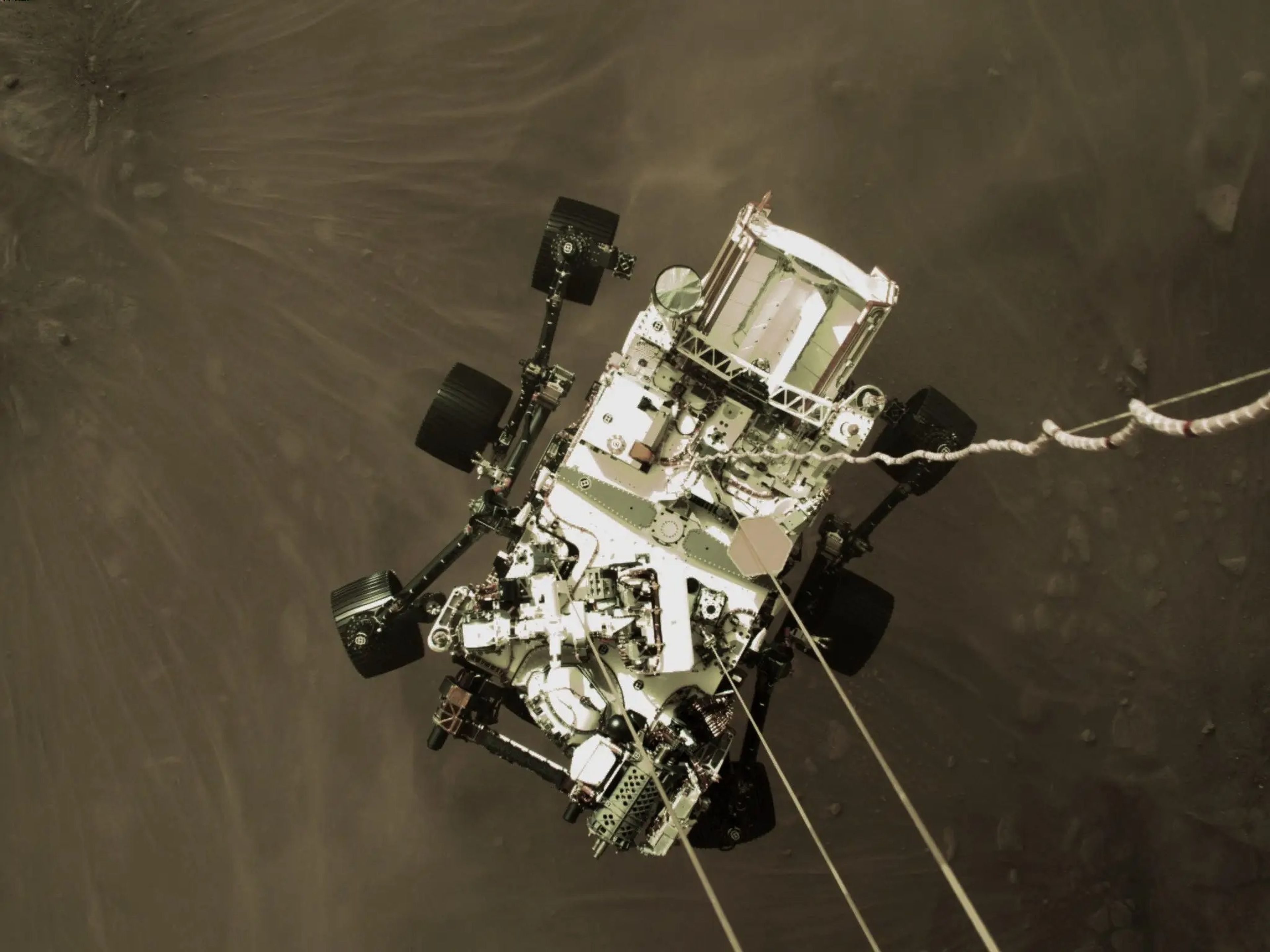 Una foto del rover Perseverance de la NASA a pocos metros sobre la superficie marciana, parte de un video que varias cámaras grabaron del aterrizaje el 18 de febrero de 2021.