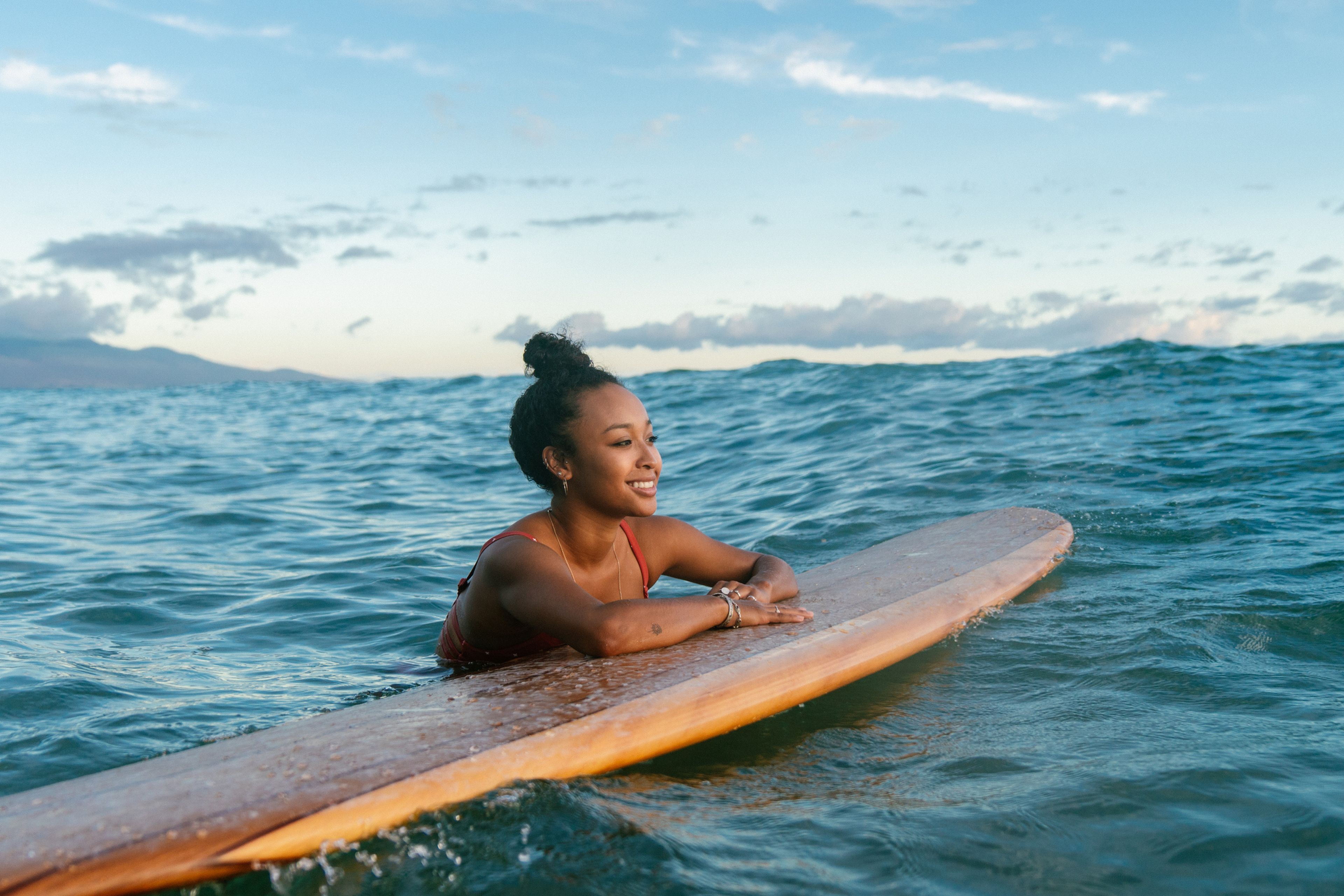 Una chica hace surf en las playas de Hawái.