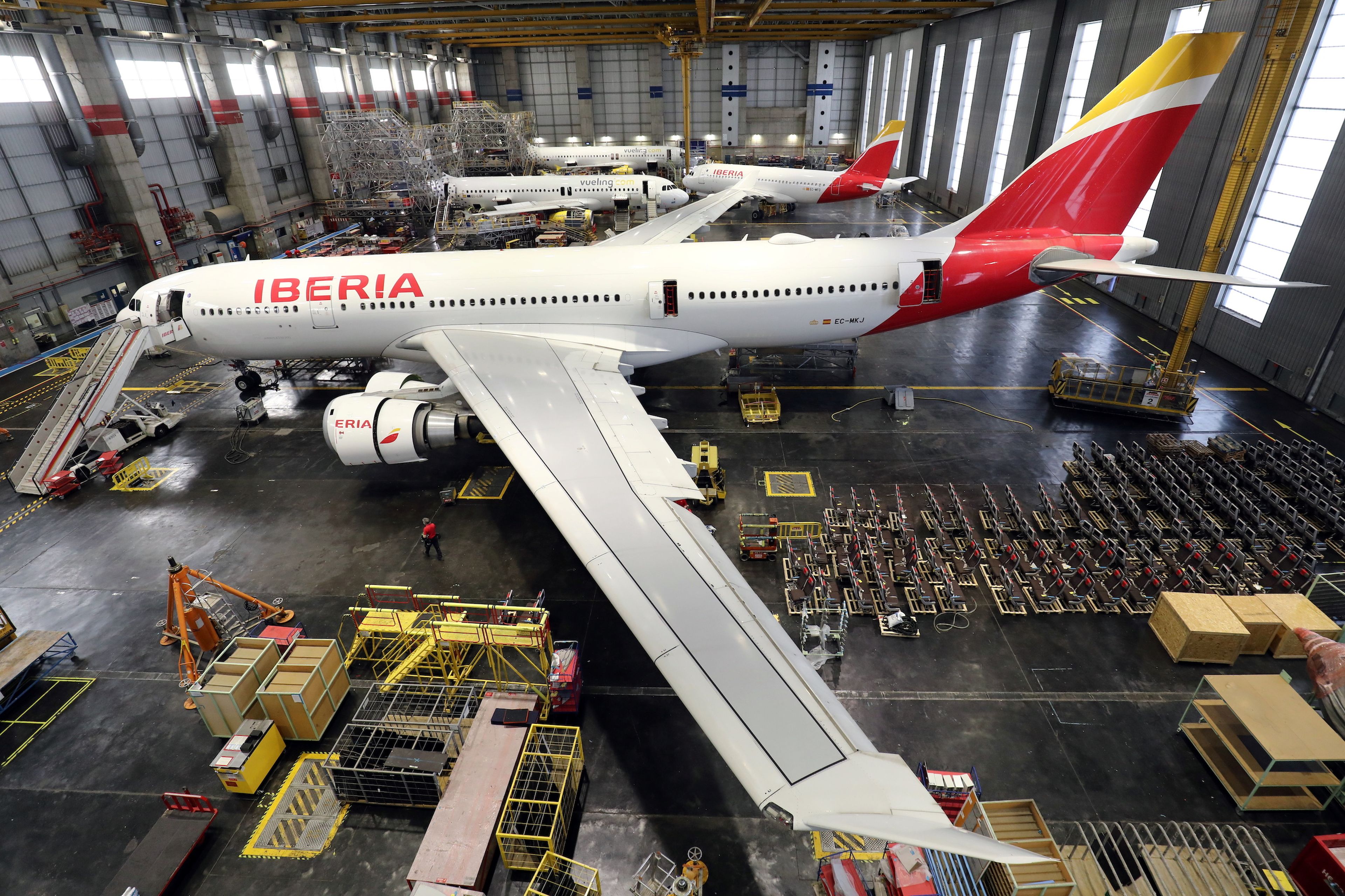 Un avión de pasajeros de Iberia siendo transformado en uno de carga en los hangares de la compañía, en Madrid.
