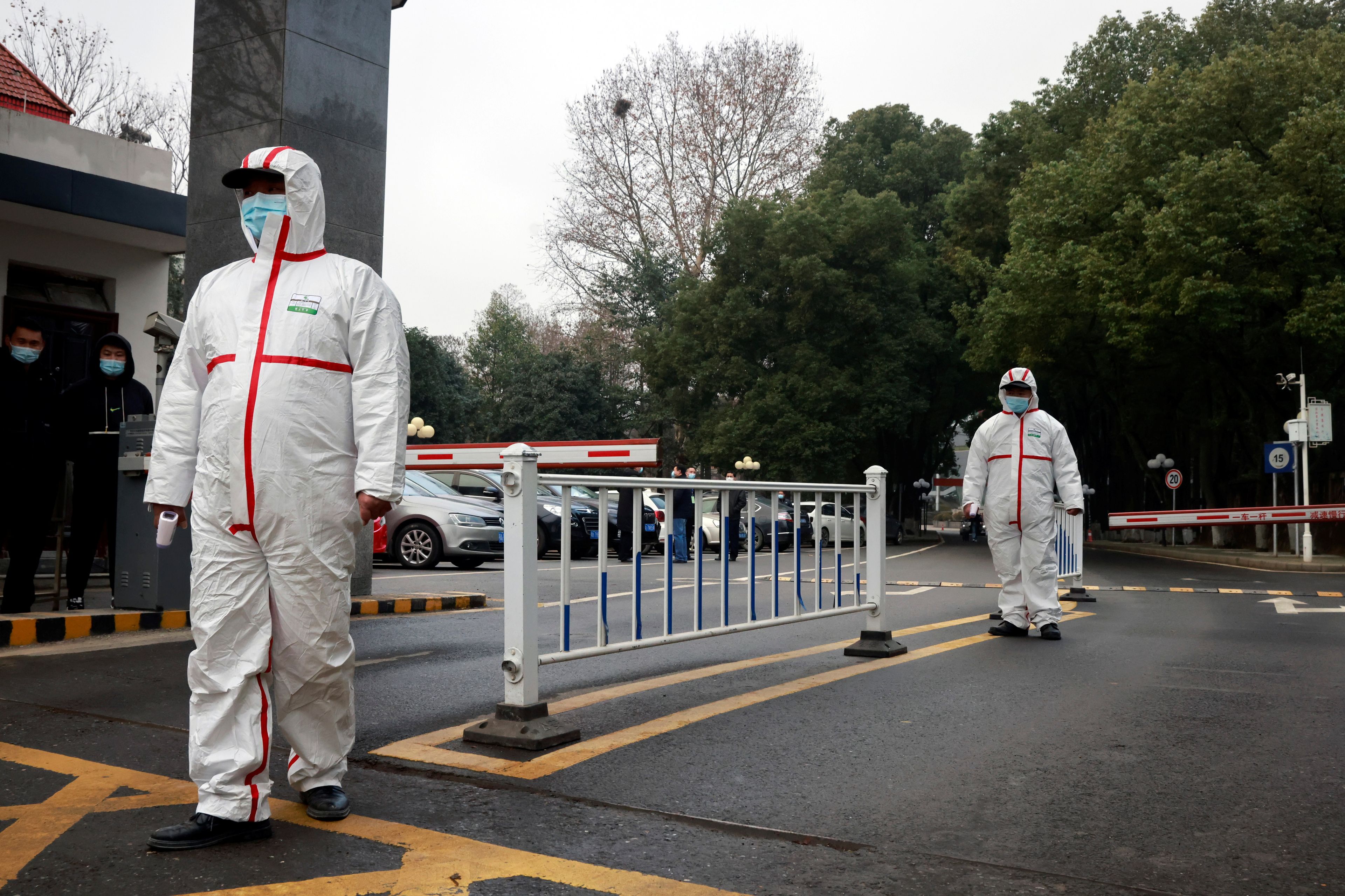 Personal de seguridad vigila durante la visita de los miembros del equipo de la OMS encargado de investigar los orígenes del coronavirus en Wuhan