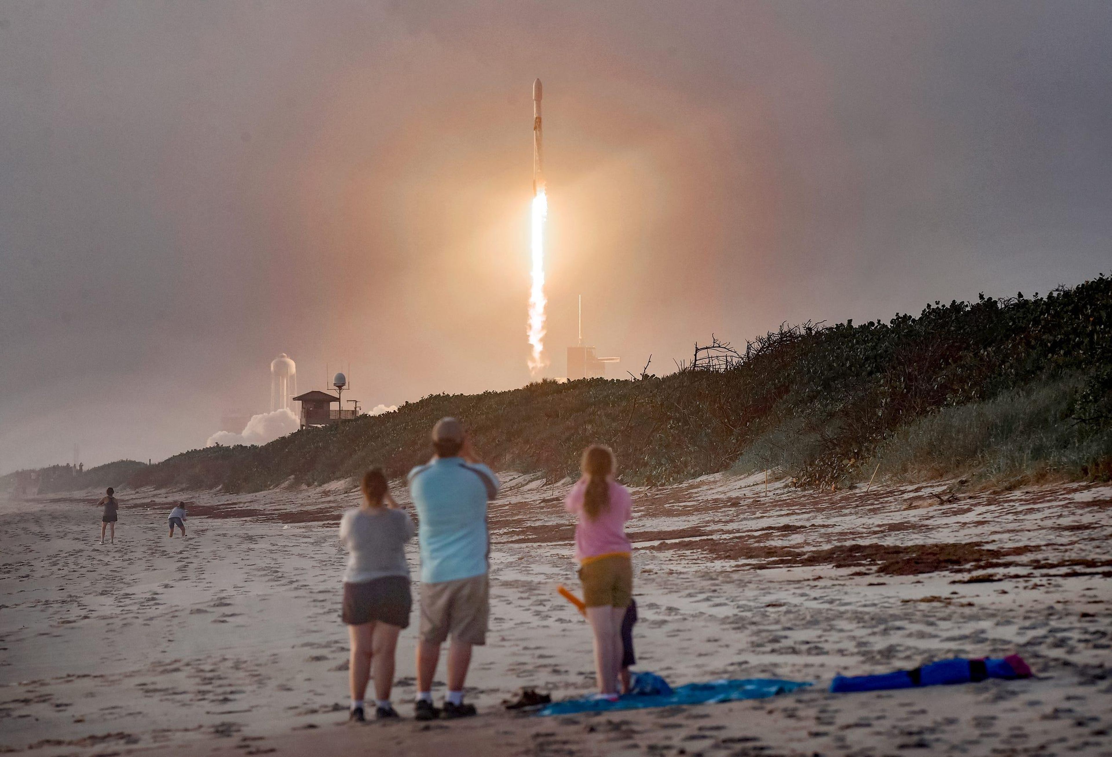 Los espectadores observan desde Canaveral National Seashore (EEUU) el lanzamiento de un cohete Falcon 9 de SpaceX con 60 satélites Starlink.