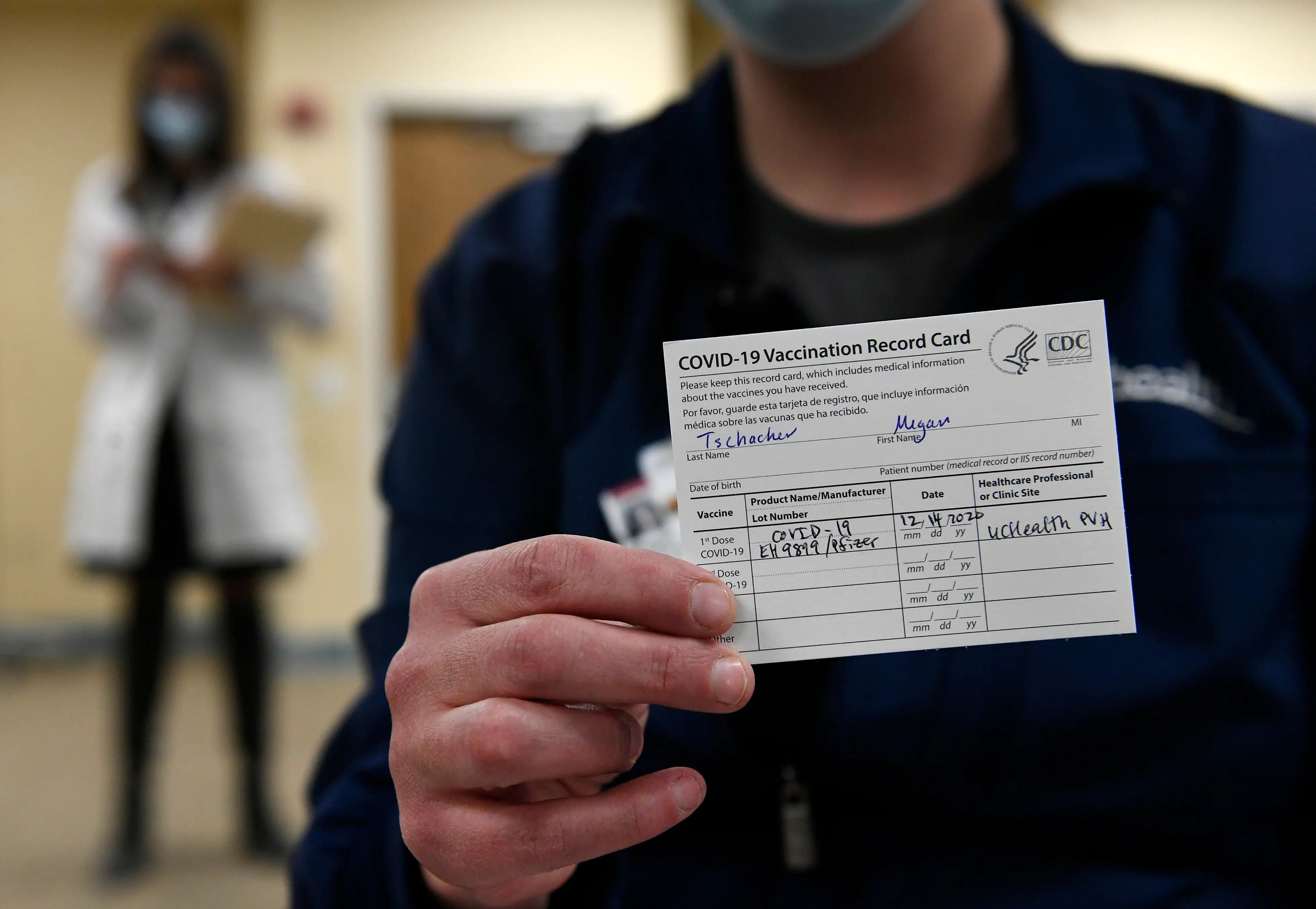 La enfermera de la UCI Megan Tschacher muestra su tarjeta de vacunación en el UC Health Poudre Valley Hospital en Fort Collins, Colorado, el 14 de diciembre de 2020.