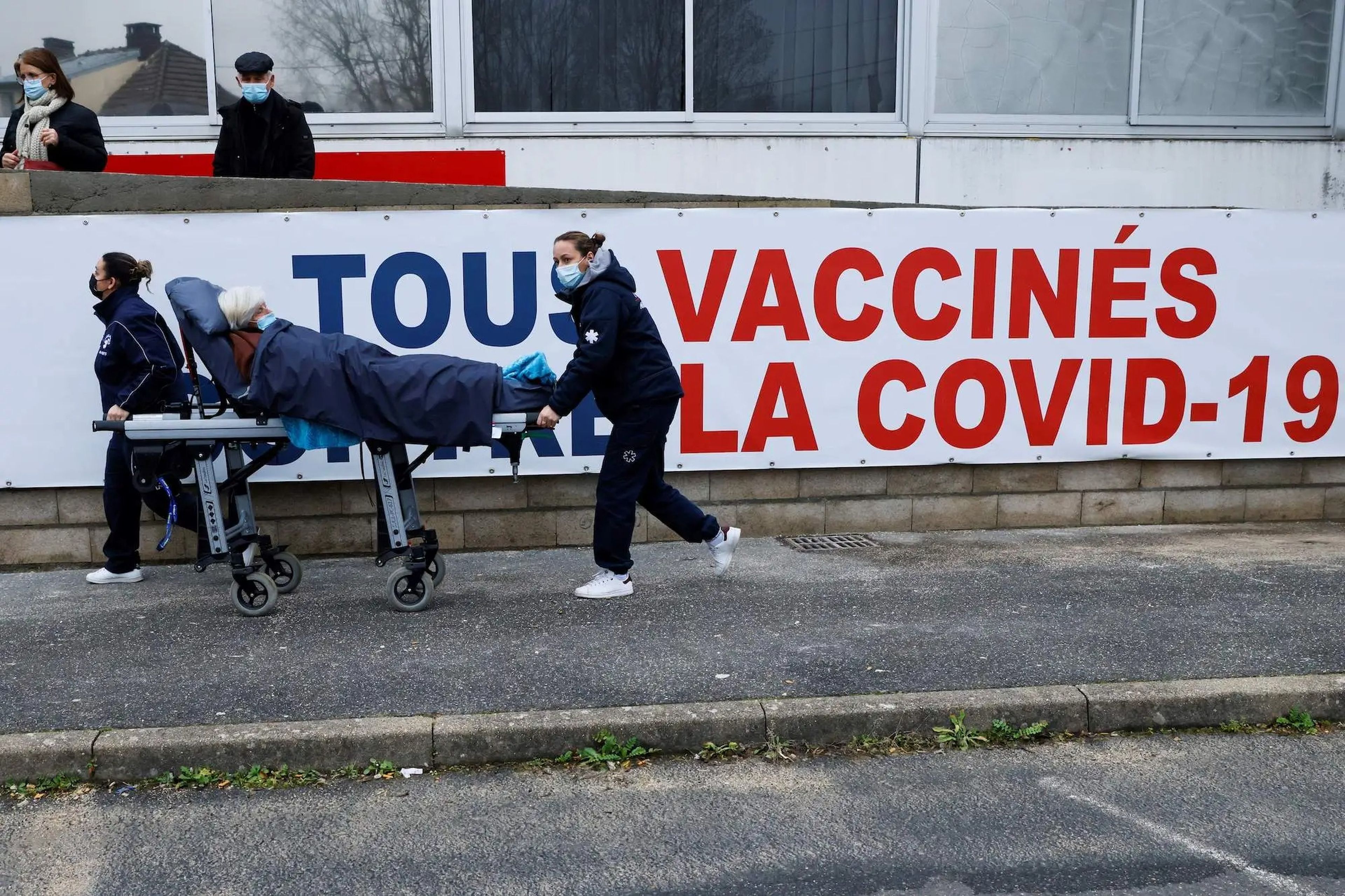 Trasladan a una mujer en una camilla al centro de vacunación COVID-19 en el Grupo Hospitalario de Ile-de-France Sur, en París, el 8 de febrero de 2021.