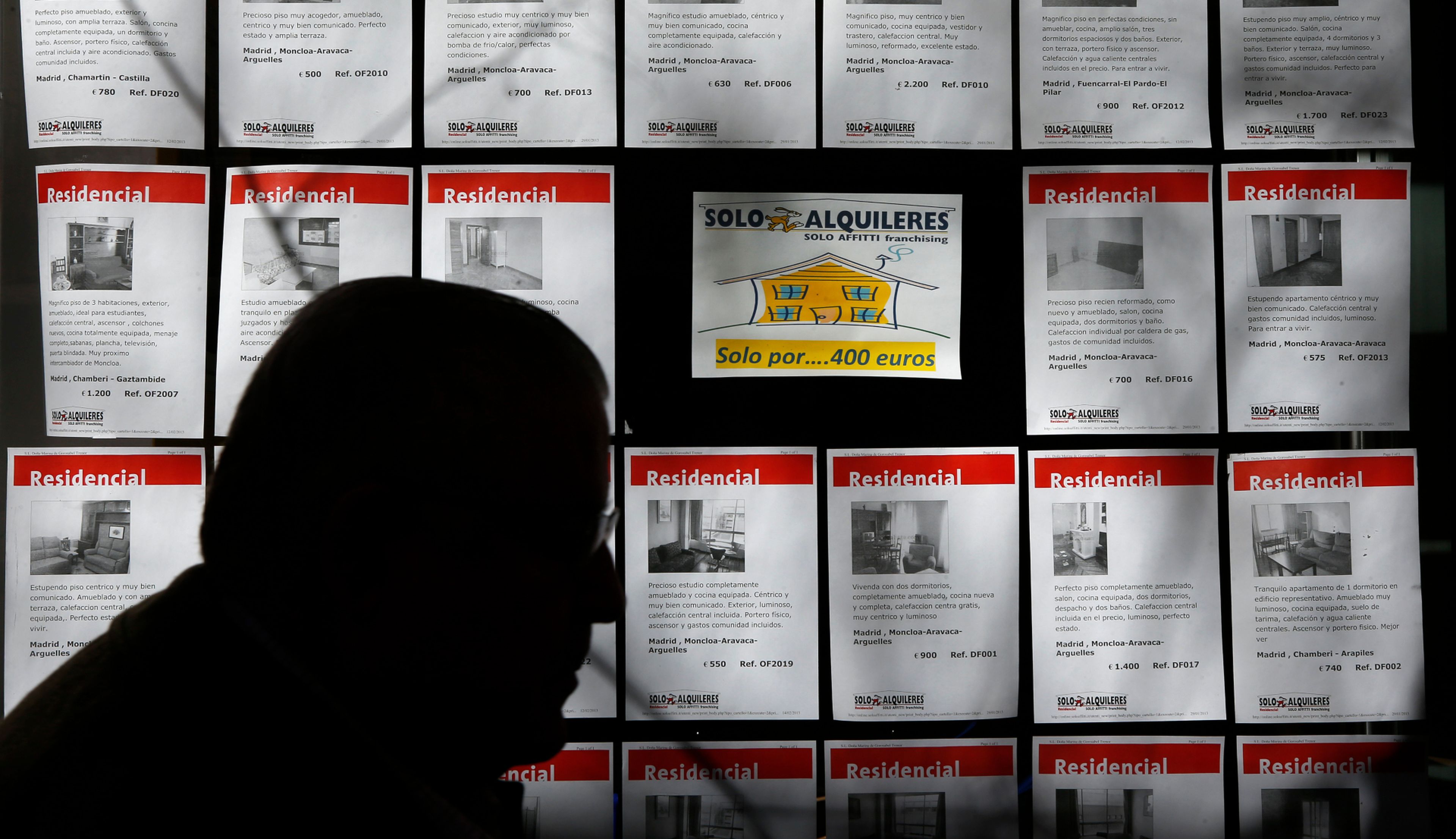 Un hombre pasa ante varios anuncios de pisos en alquiler en una inmobiliaria en Madrid