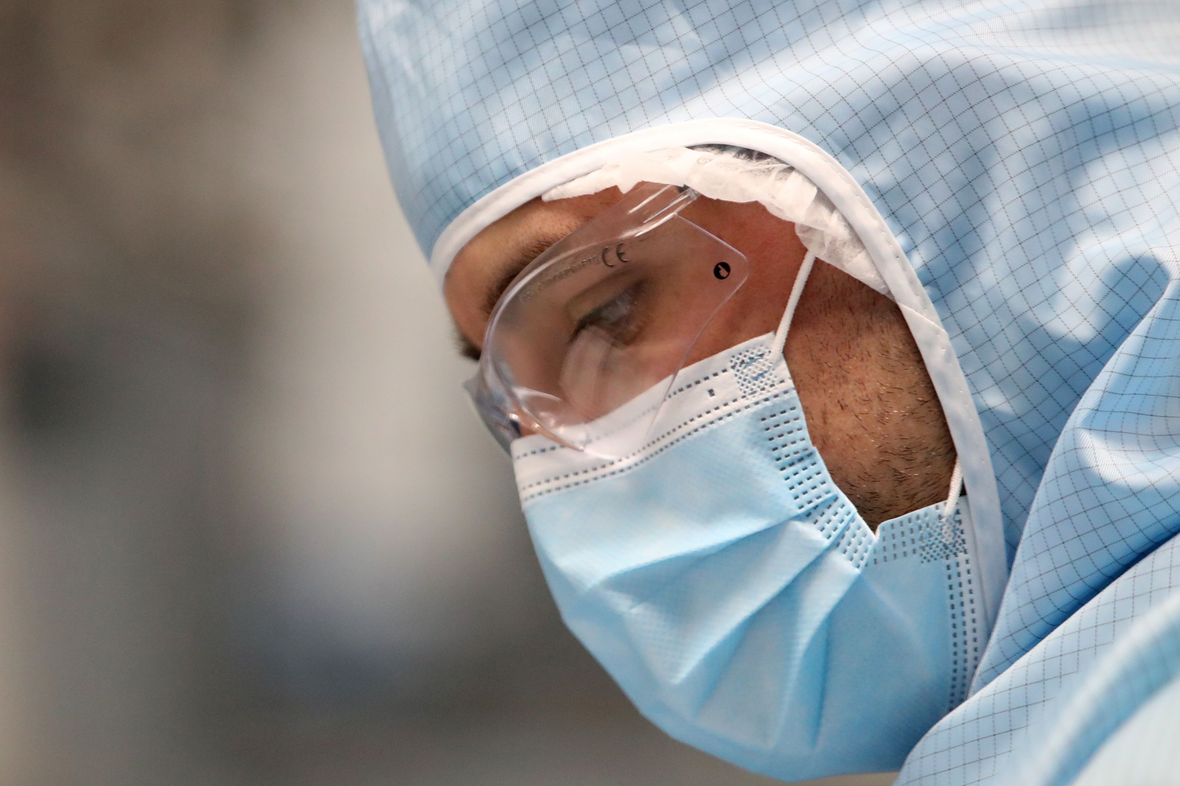 Un médico tapado mientras manipula curas para el COVID