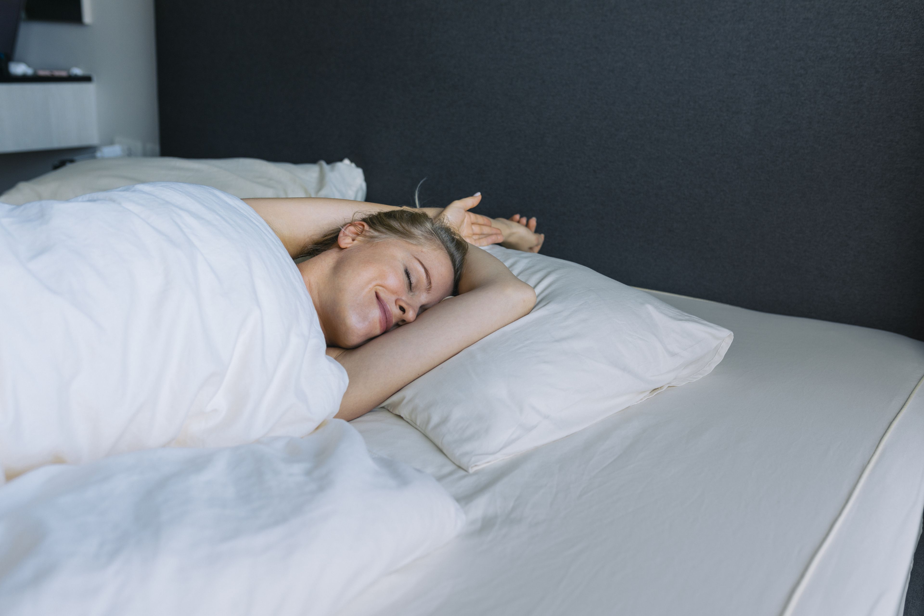 mujer en la cama, beneficios de dormir desnudo