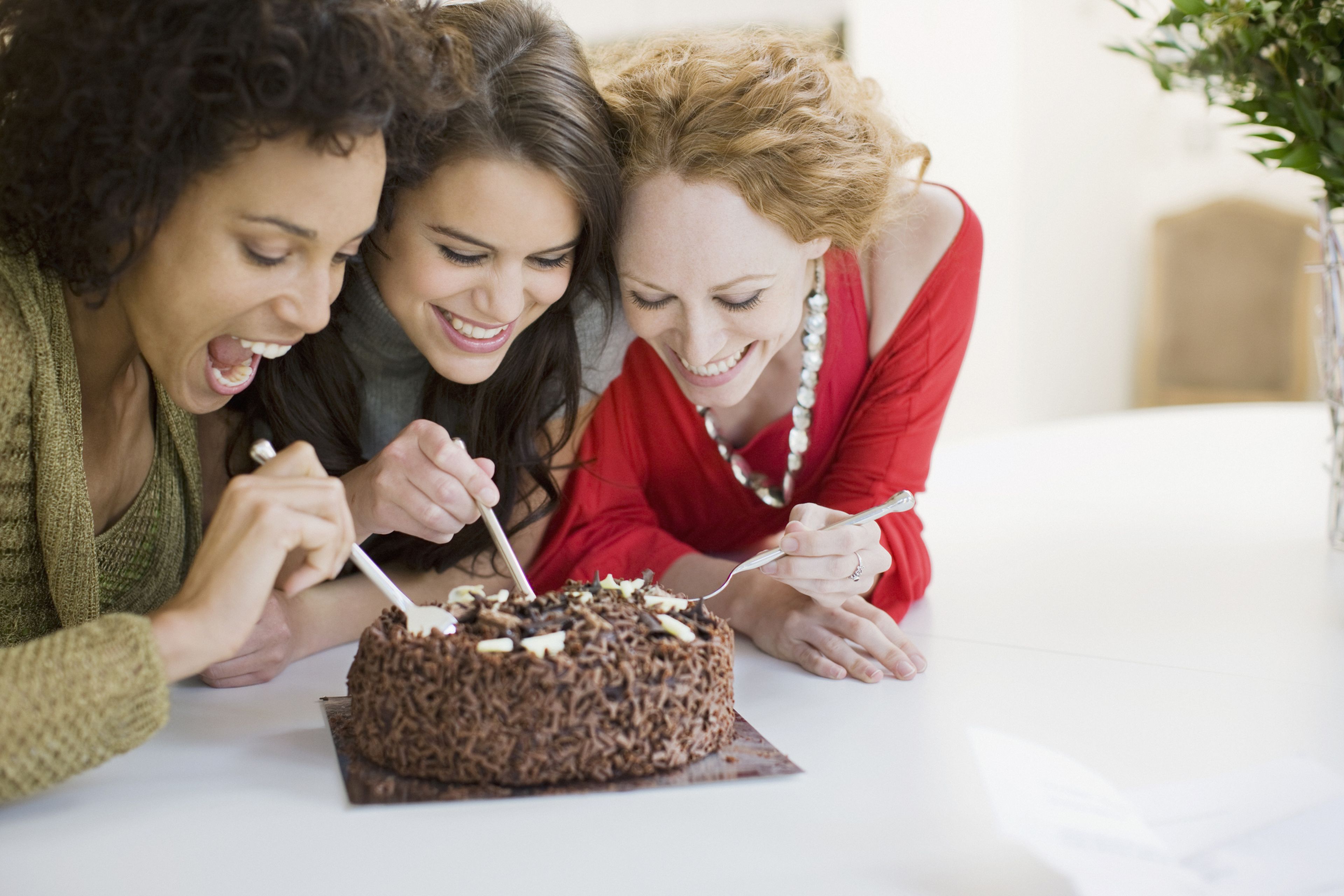 Mujeres comiendo una tarta de chocolate.