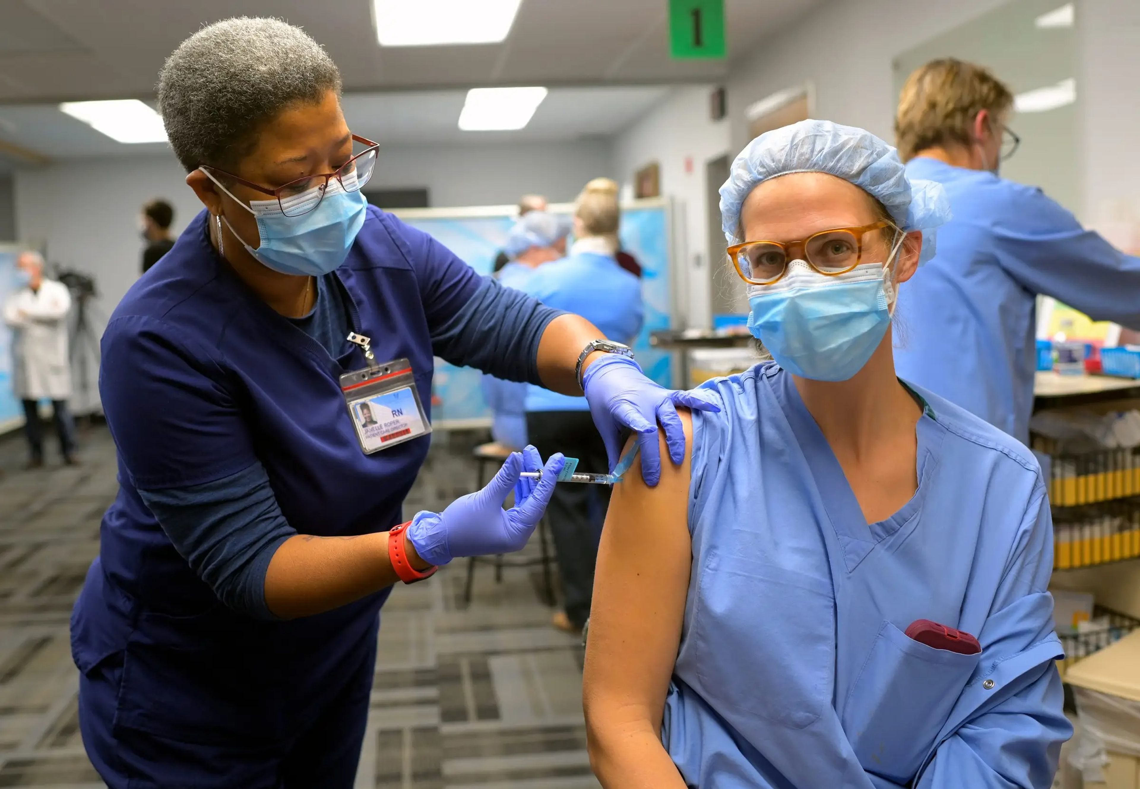 RN Janelle Roper, left, administers the Pfizer Covid-19 vaccine to Nurse Anesthetist Kate-Alden Hartman.