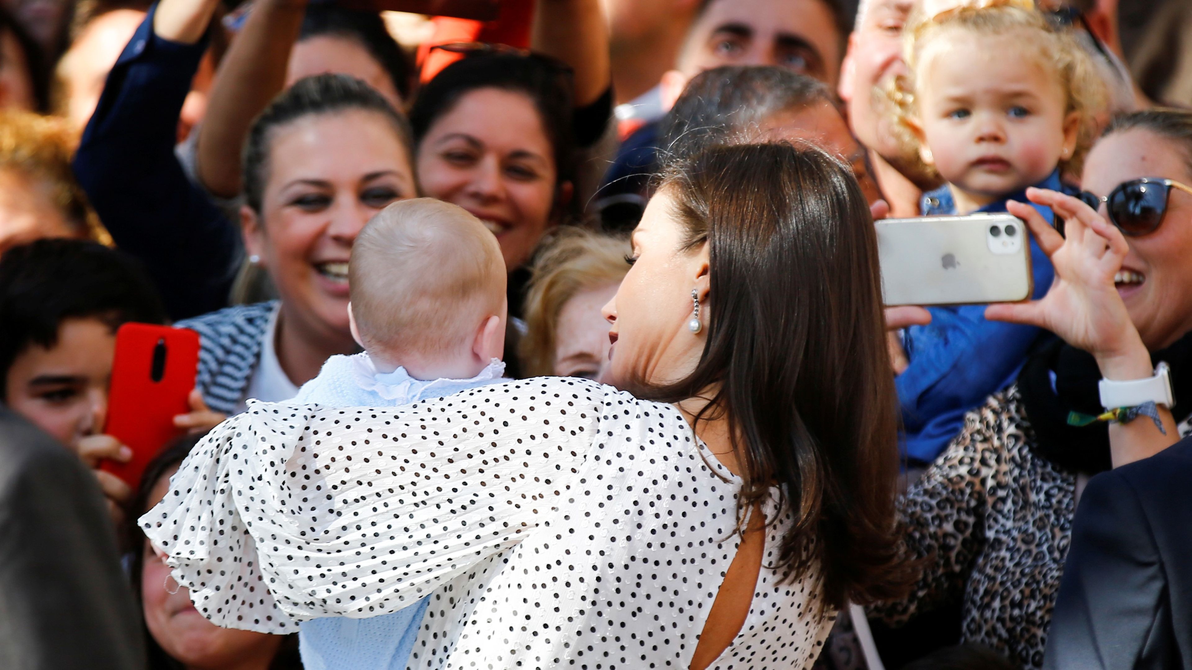 La reina Letizia de España sostiene a un bebé en brazos en su visita a Almonte, Huelva.