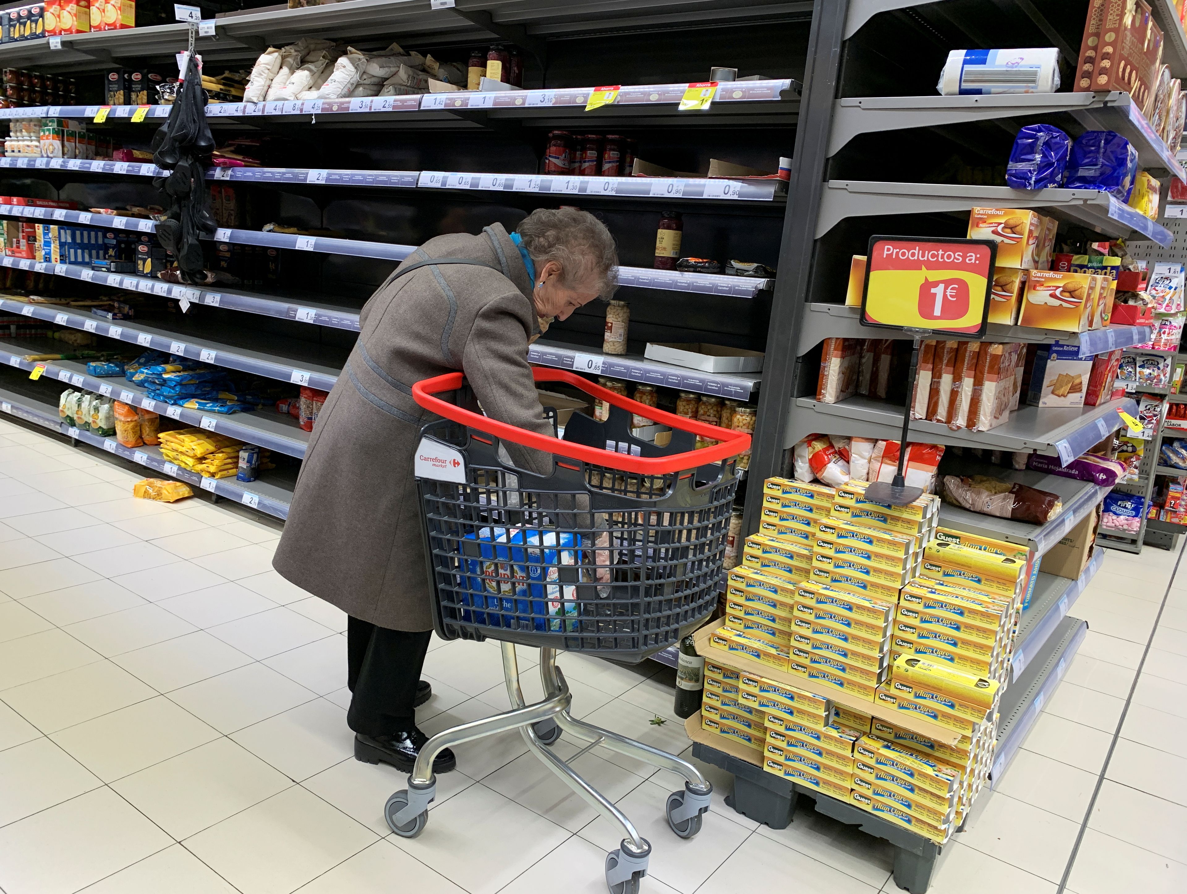 Una señora compra en un supermercado vacío en Madrid.