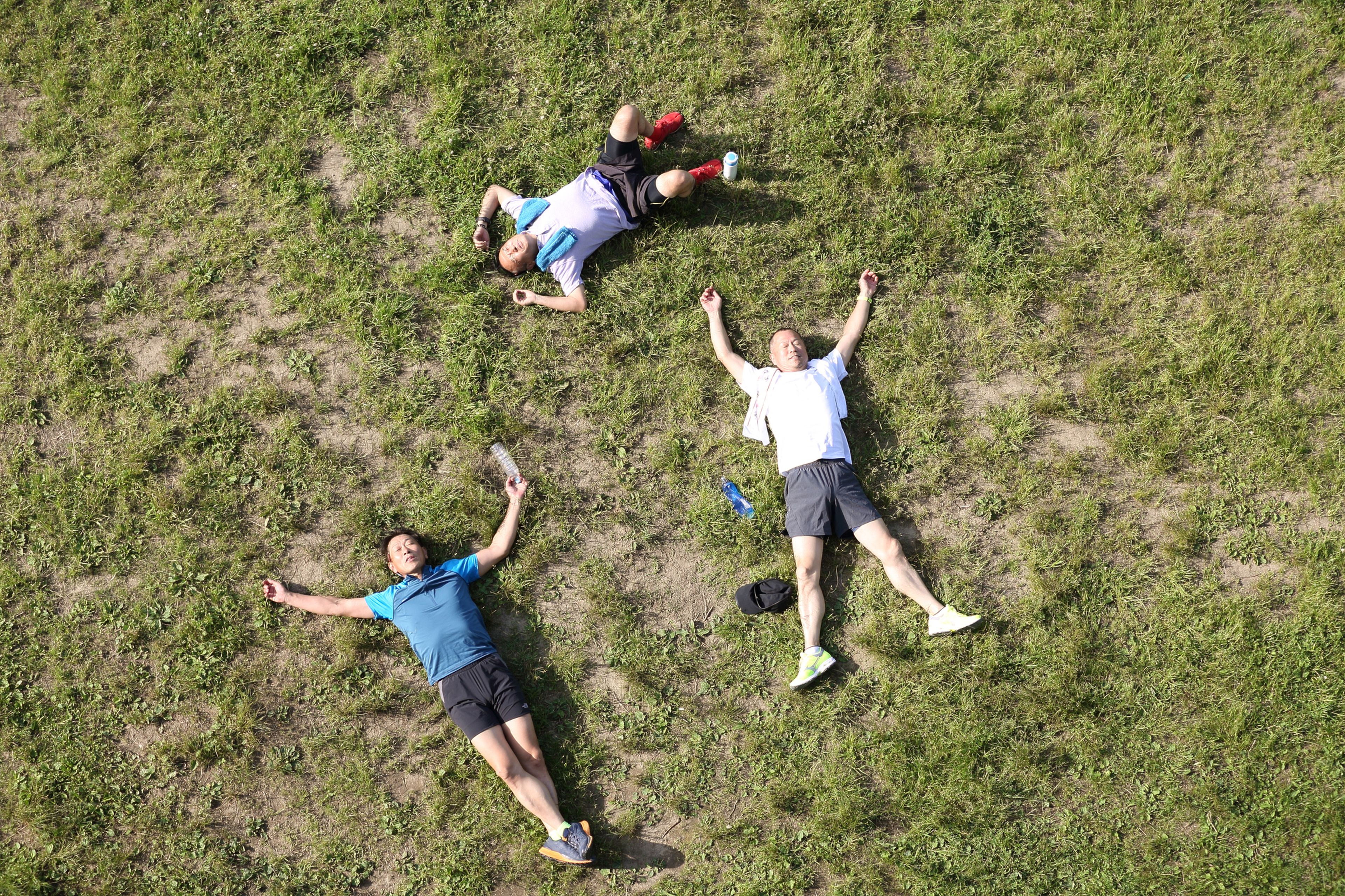 Tres hombres descansan tirados en el suelo