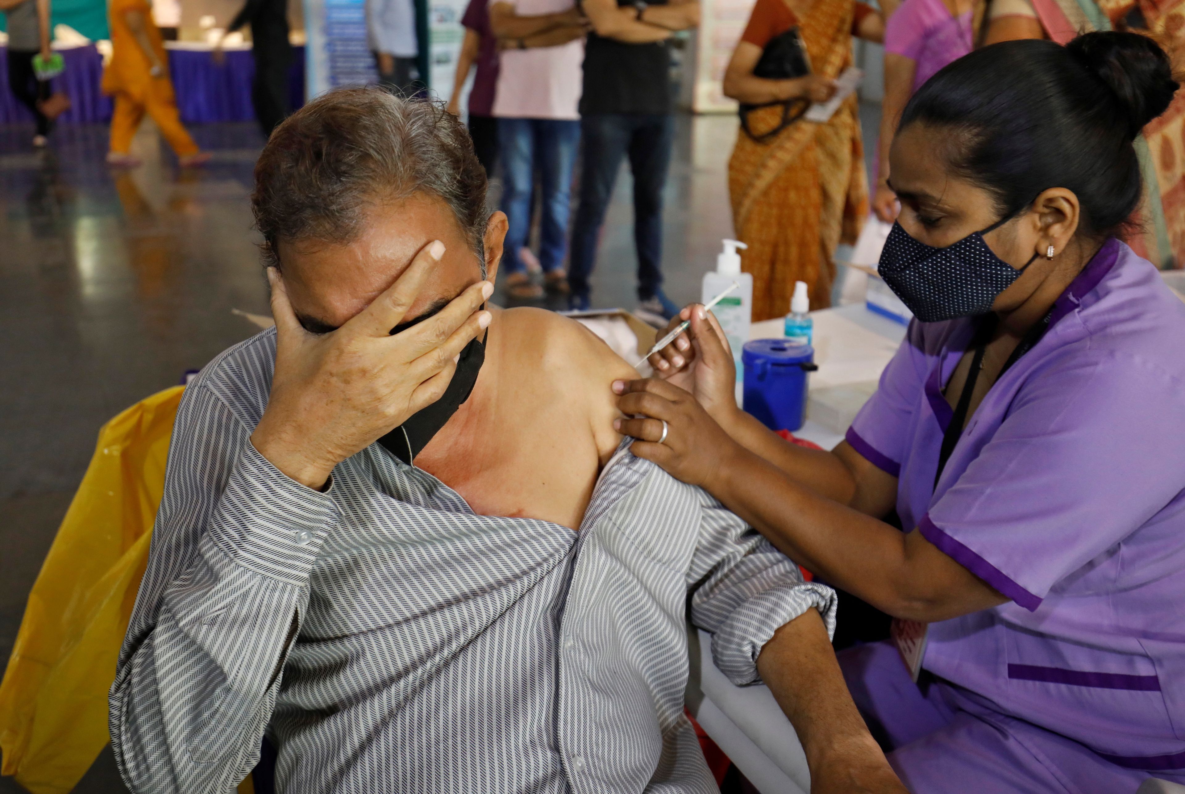 Un hombre es vacunado contra el virus del COVID-19 en India.