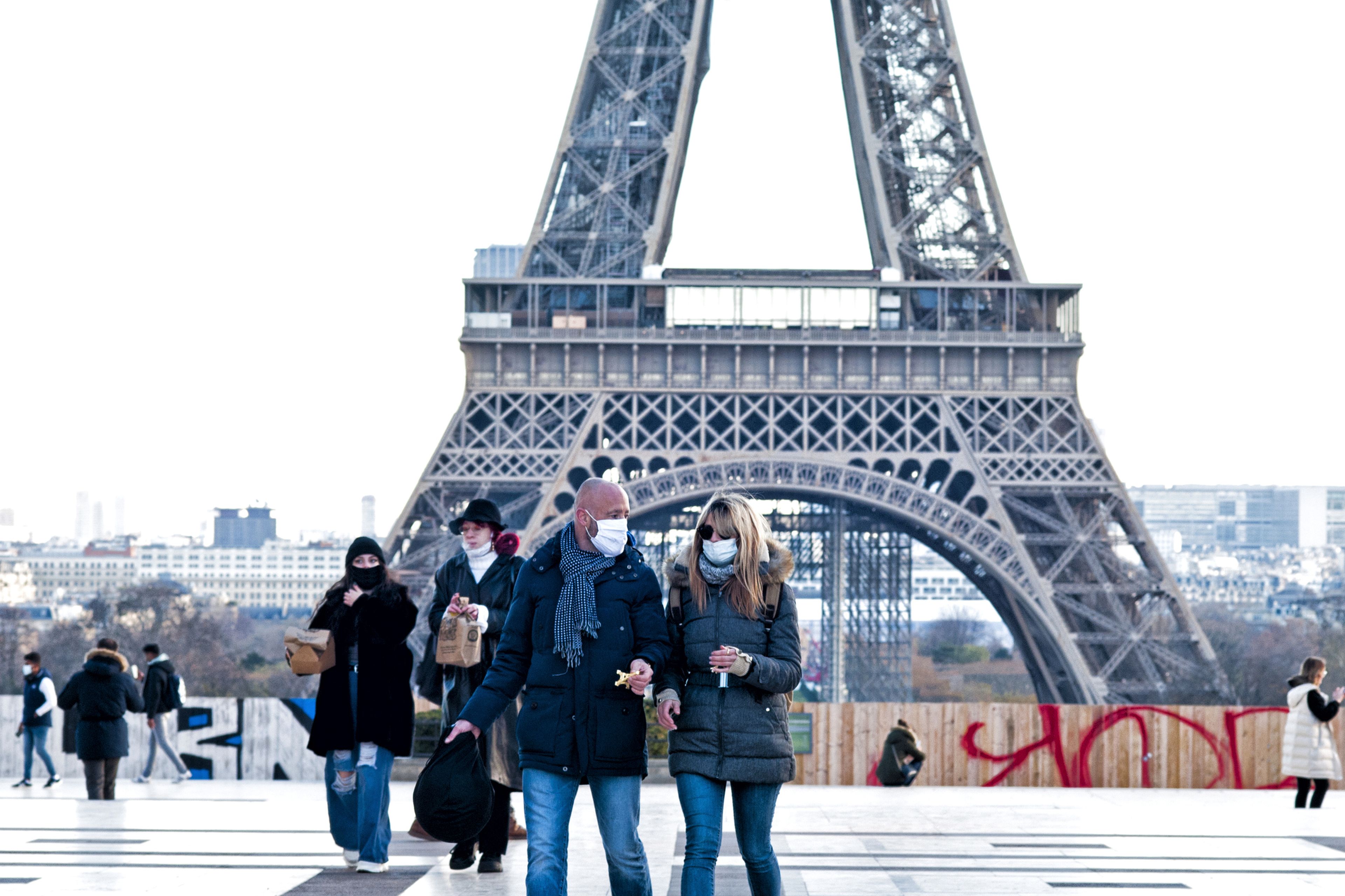 Varias personas pasean por el entorno de la Torre Eiffel en París