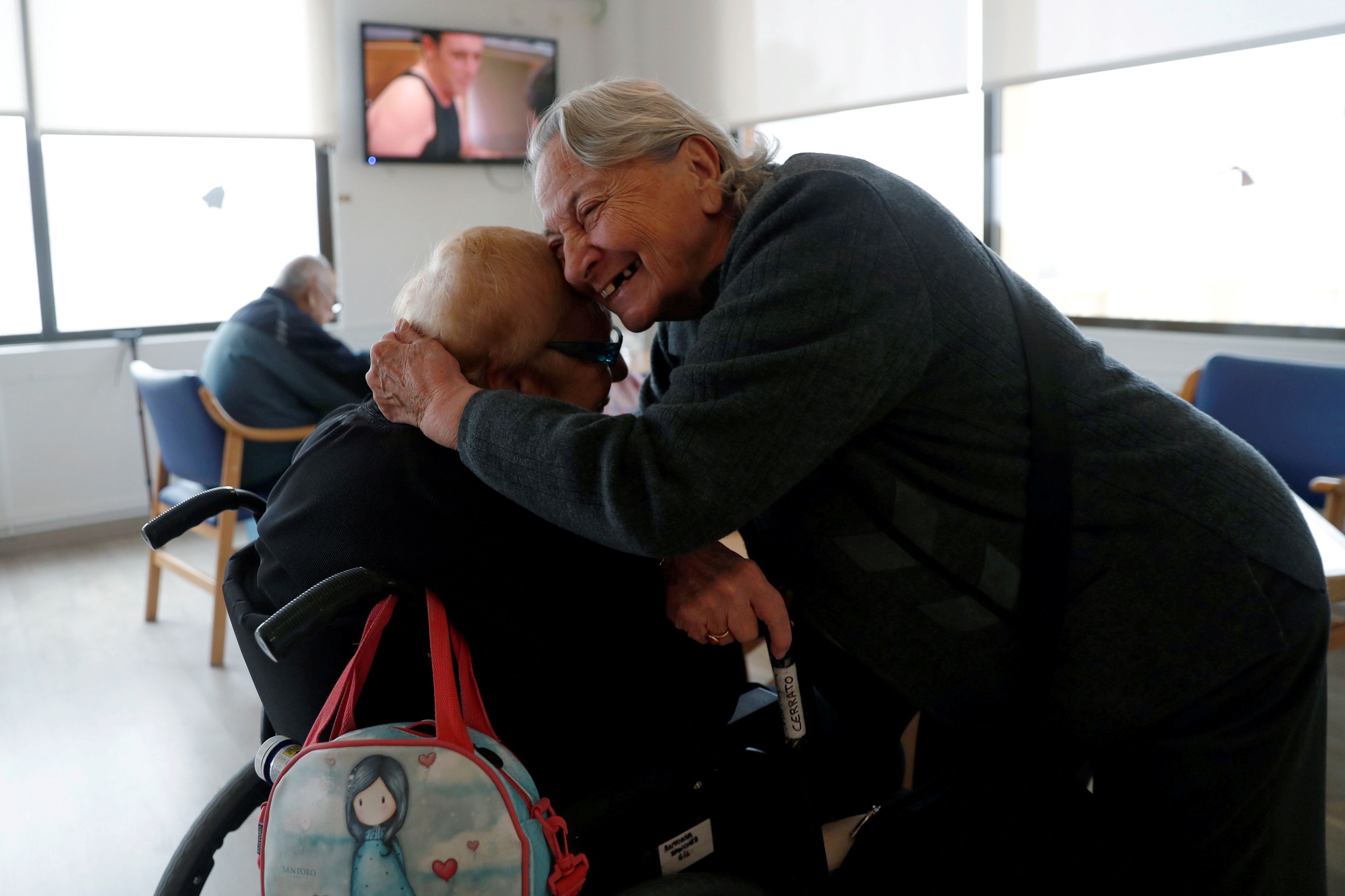 Ancianos de una residencia dándose un abrazo