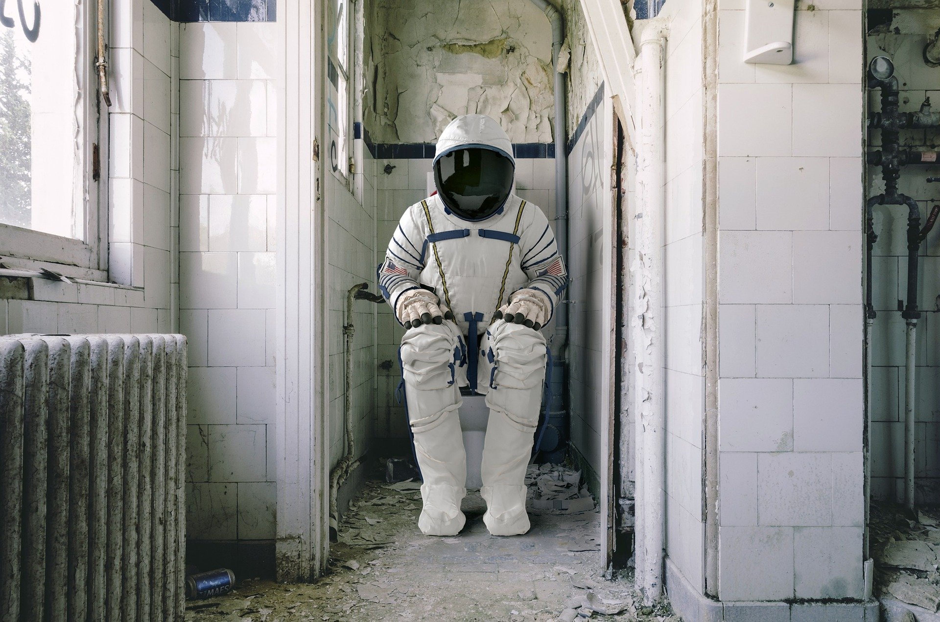 Un astronauta sentado en la taza del váter.