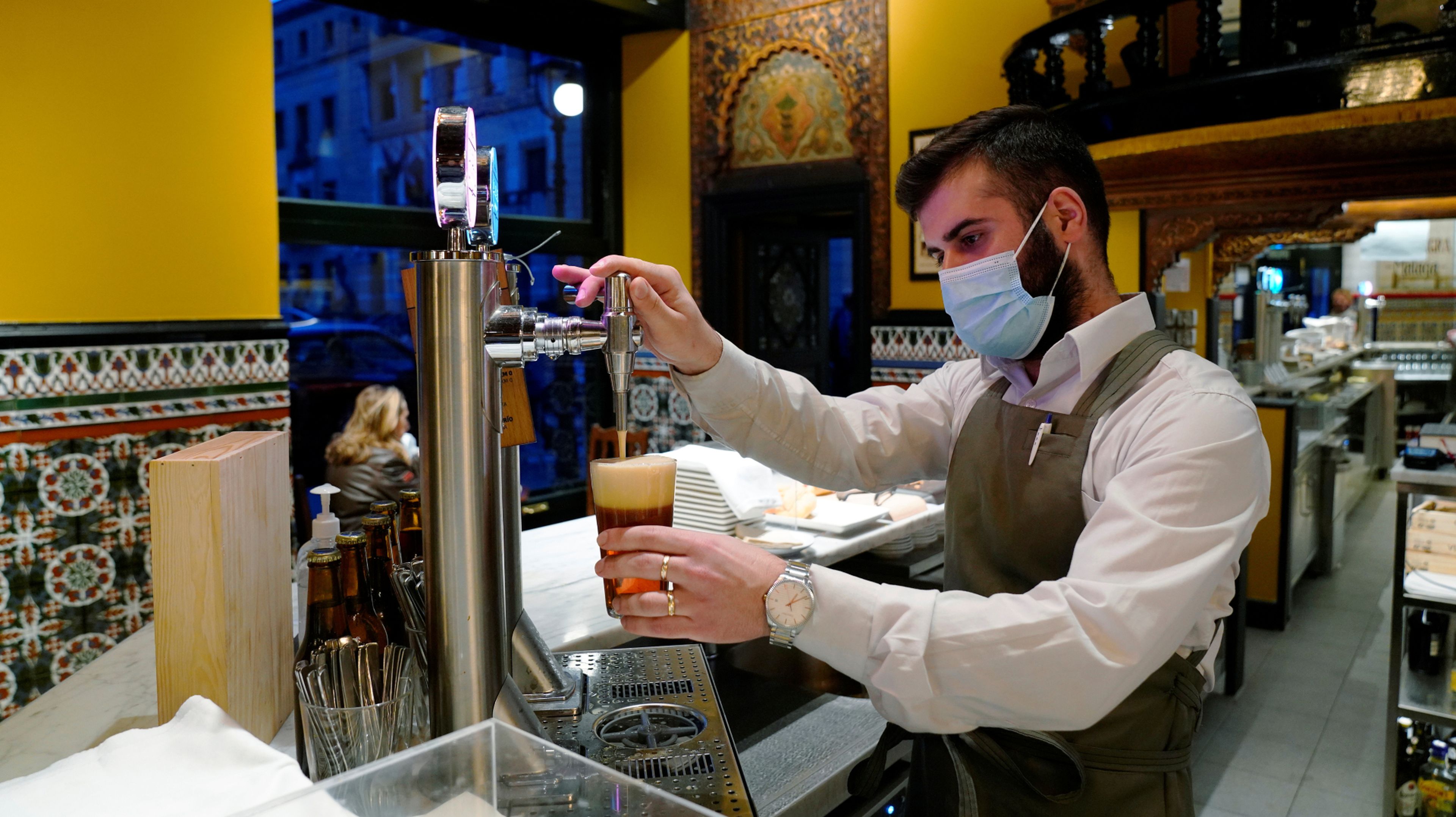 Un camarero tira una caña de cerveza en un bar de Madrid