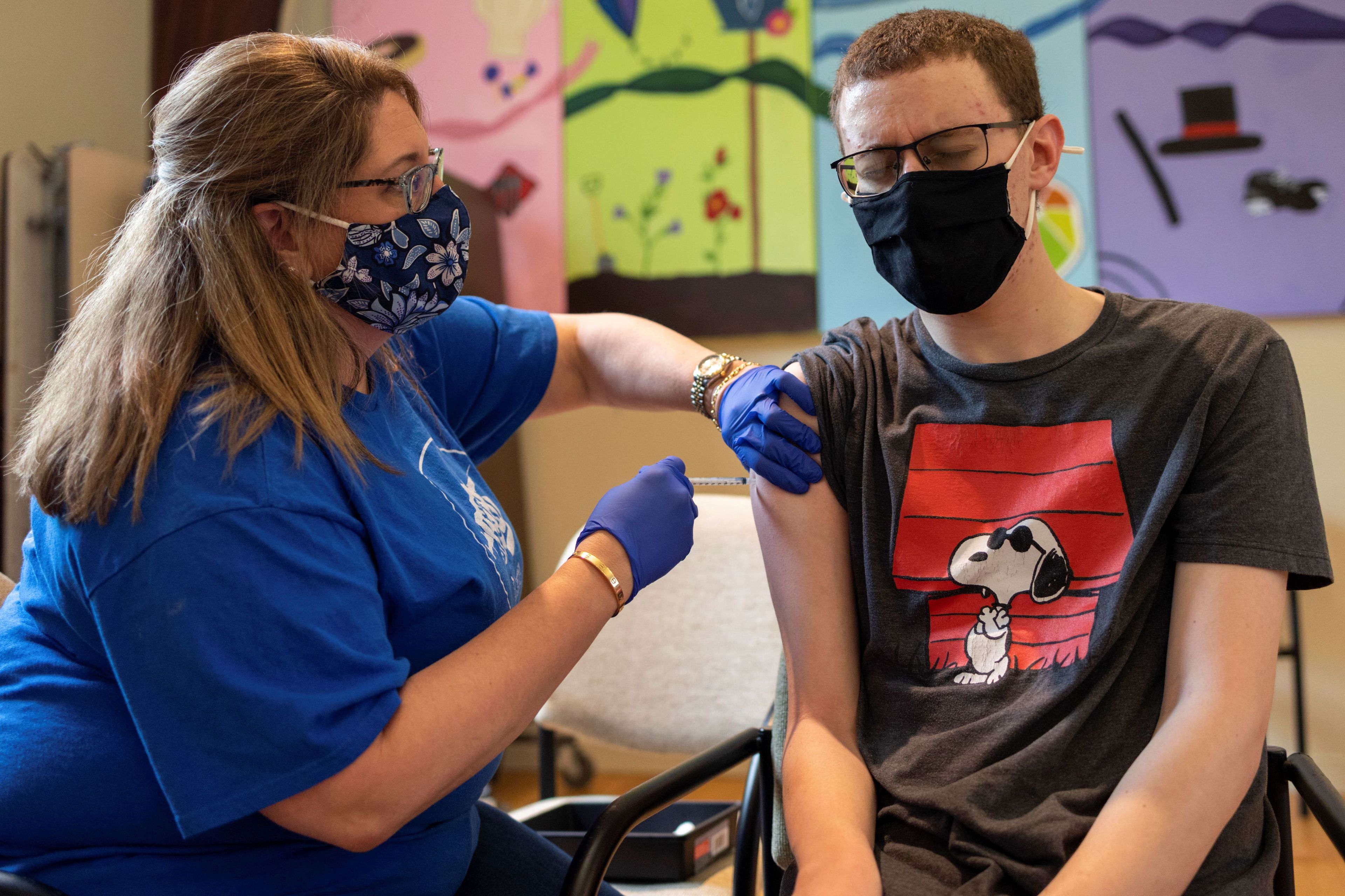 Un chico joven recibe una vacuna contra el COVID-19