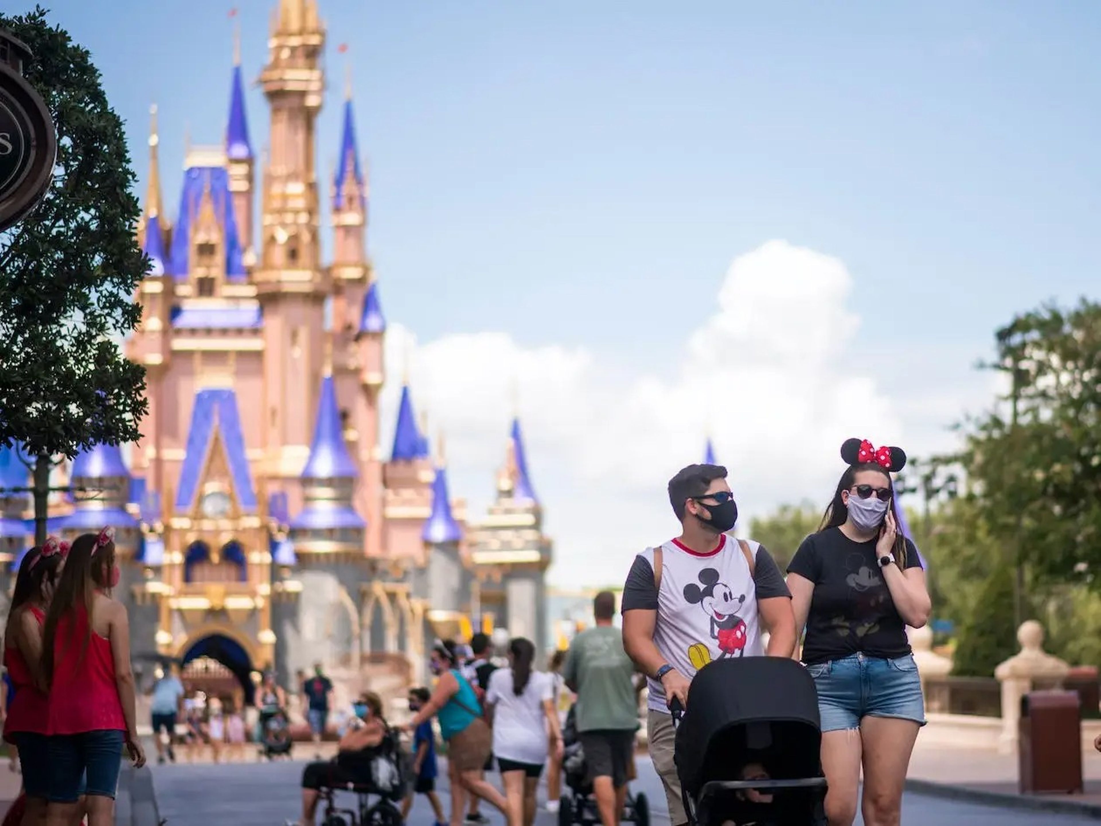 Varias personas con mascarilla en un parque de Walt Disney.