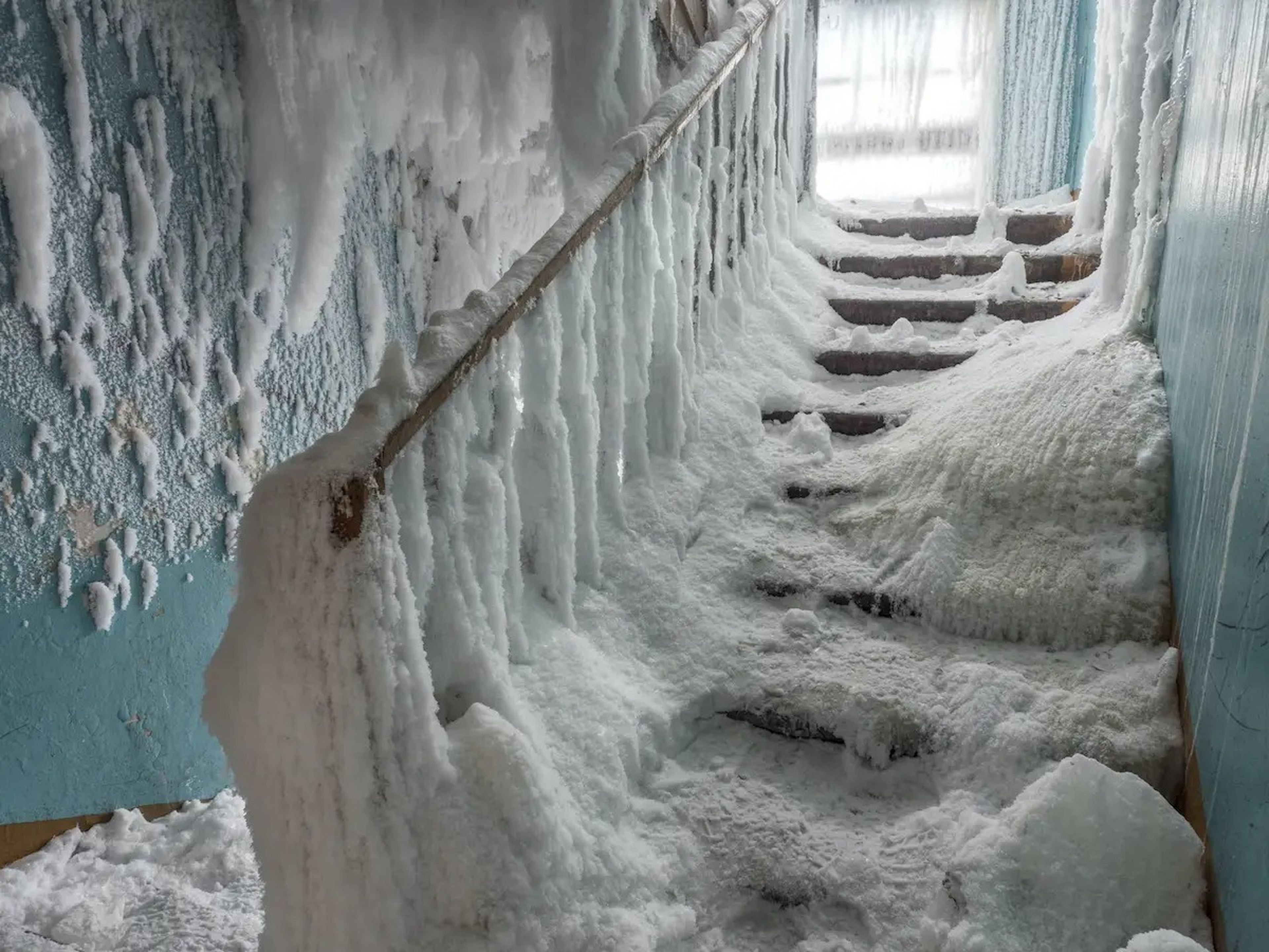En algunos edificios, la nieve cubre las escaleras y de las barandillas cuelgan carámbanos.