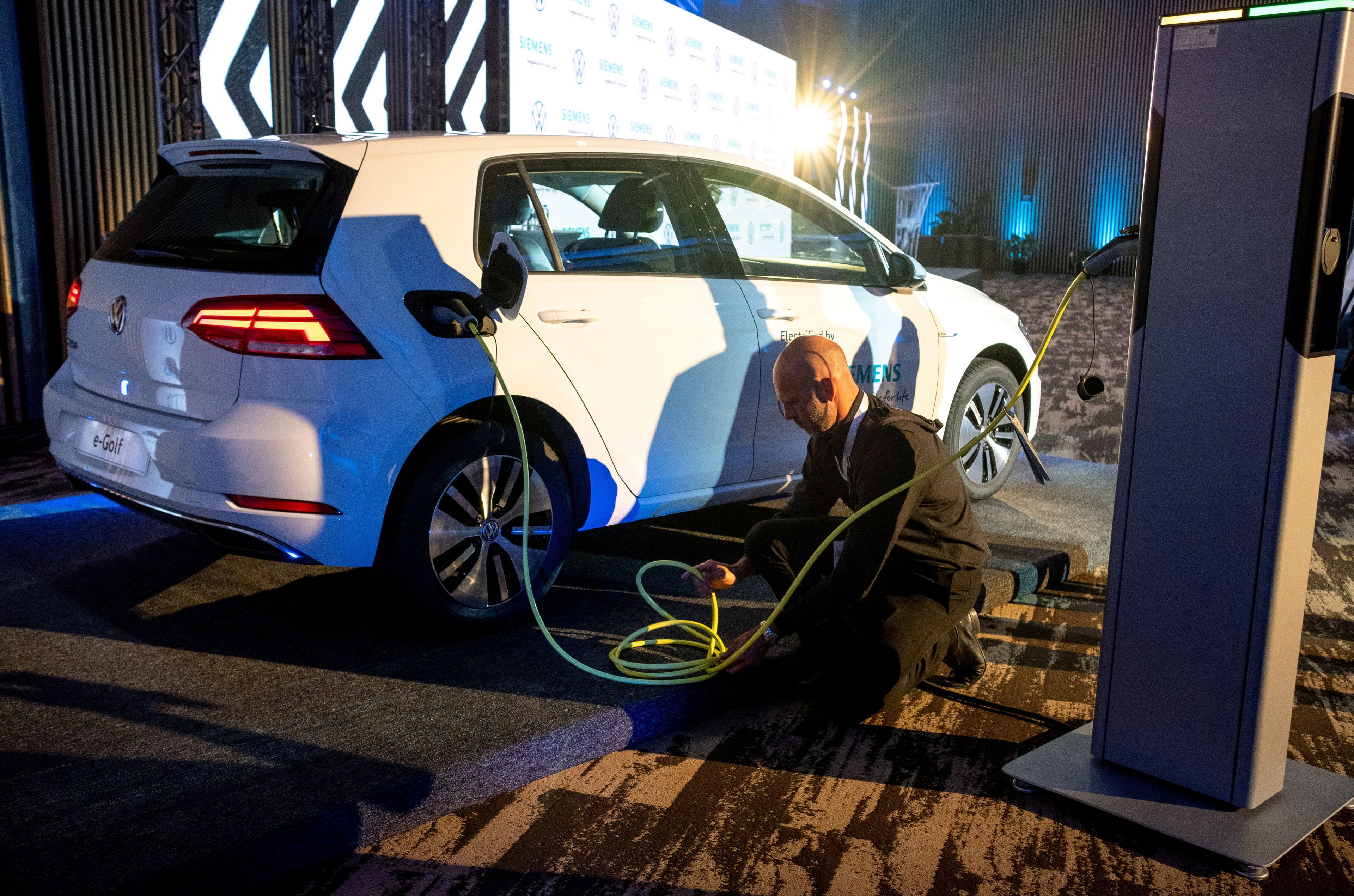Un hombre carga un coche eléctrico