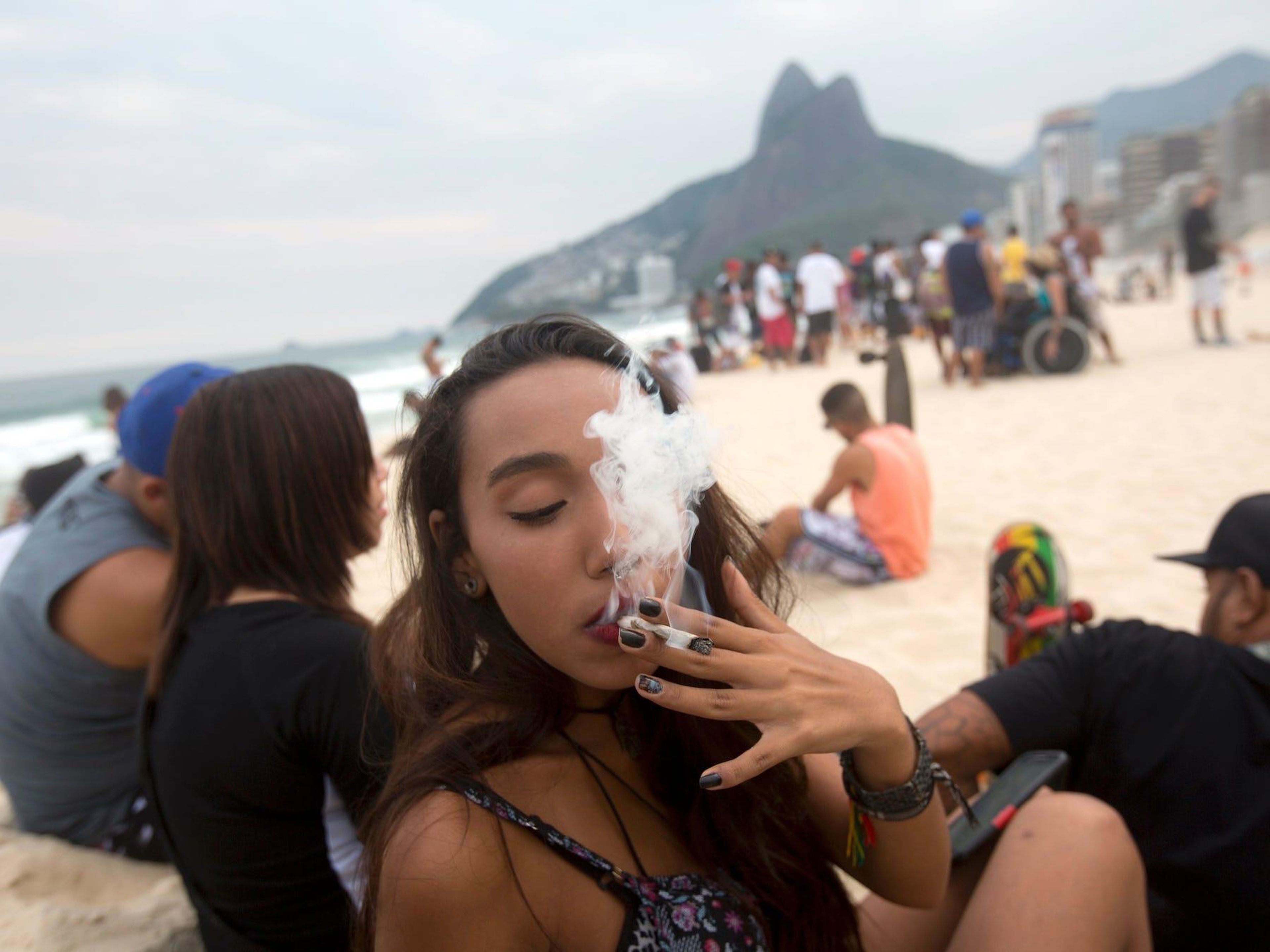 Una mujer fuma un porro de marihuana durante la 'Marcha de la Marihuana' en la playa de Ipanema, en Río de Janeiro, Brasil, el sábado 7 de mayo de 2016.