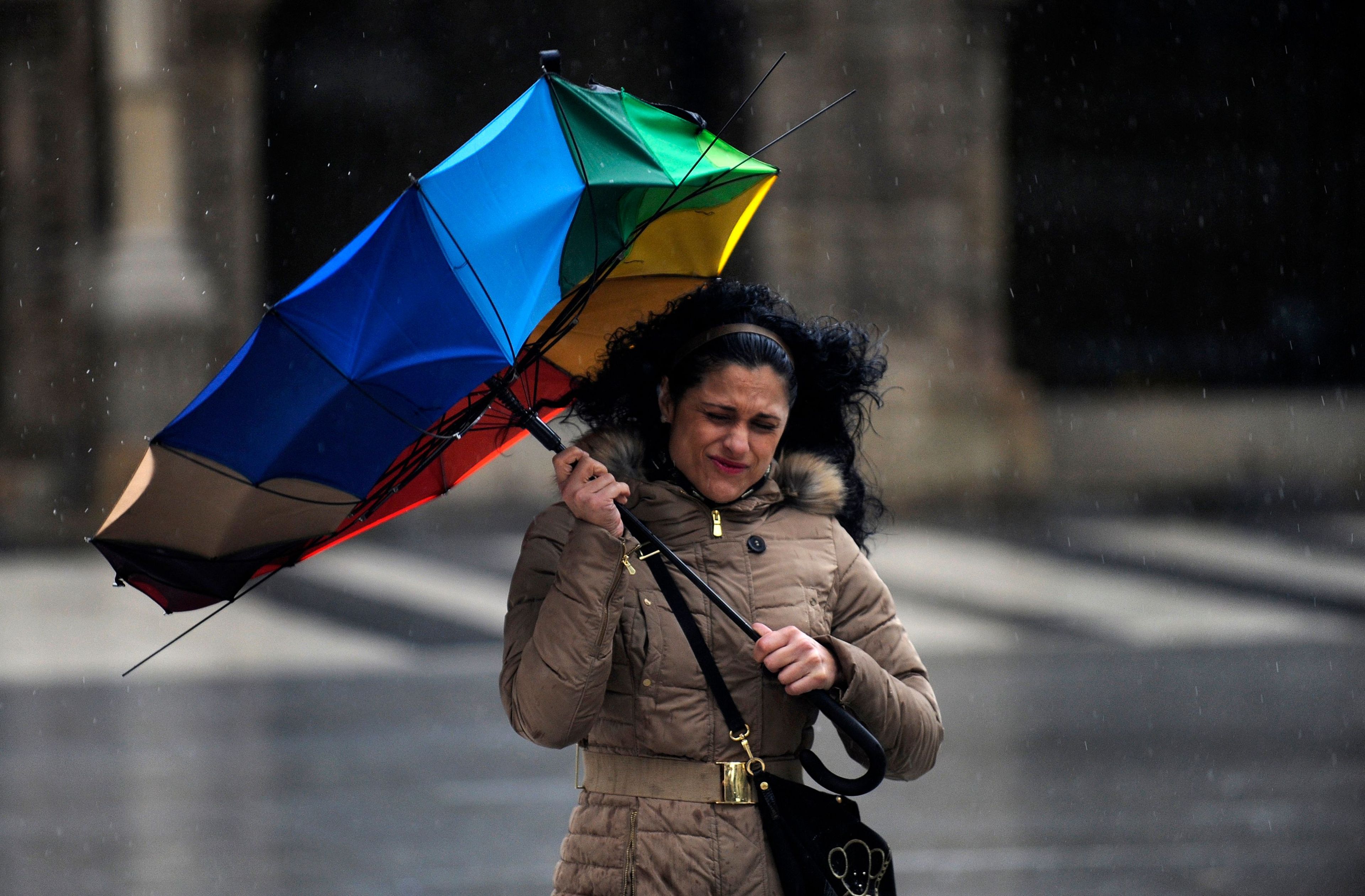 Una mujer se cubre con un paraguas