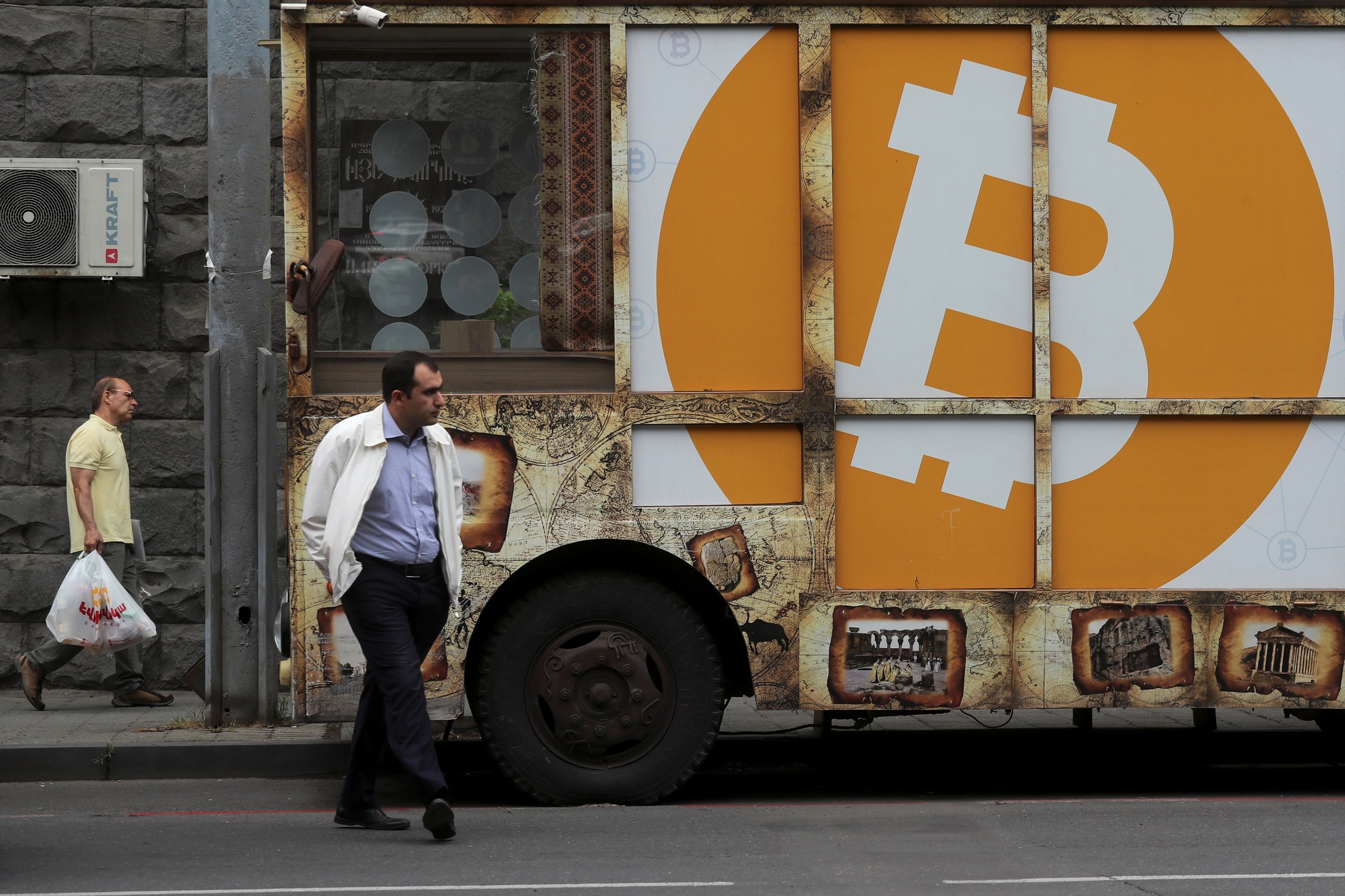 Una persona camina con el logo de bitcoin detras