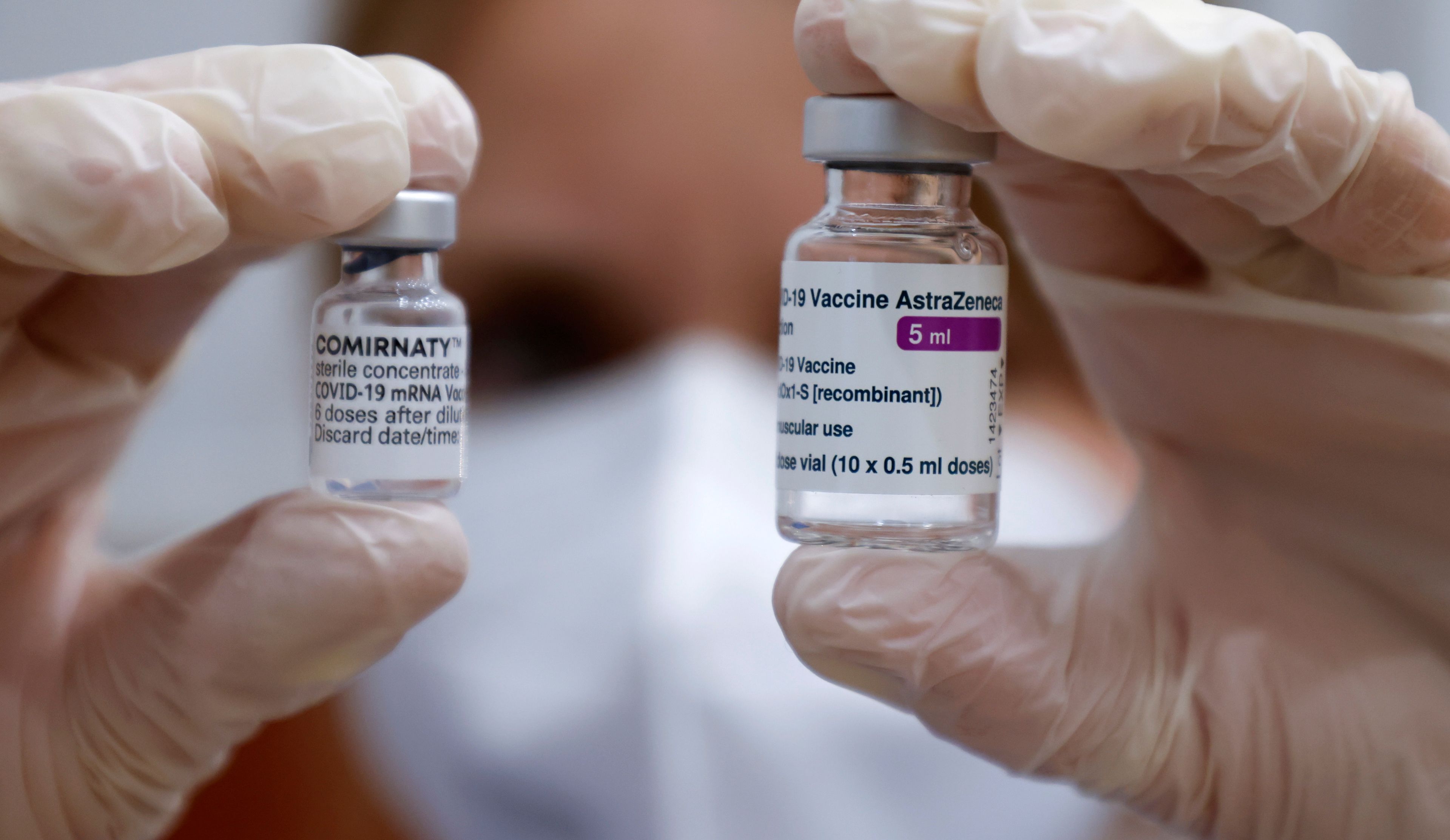 Un sanitario muestra dos viales de vacunas de Pfizer y AstraZeneca.