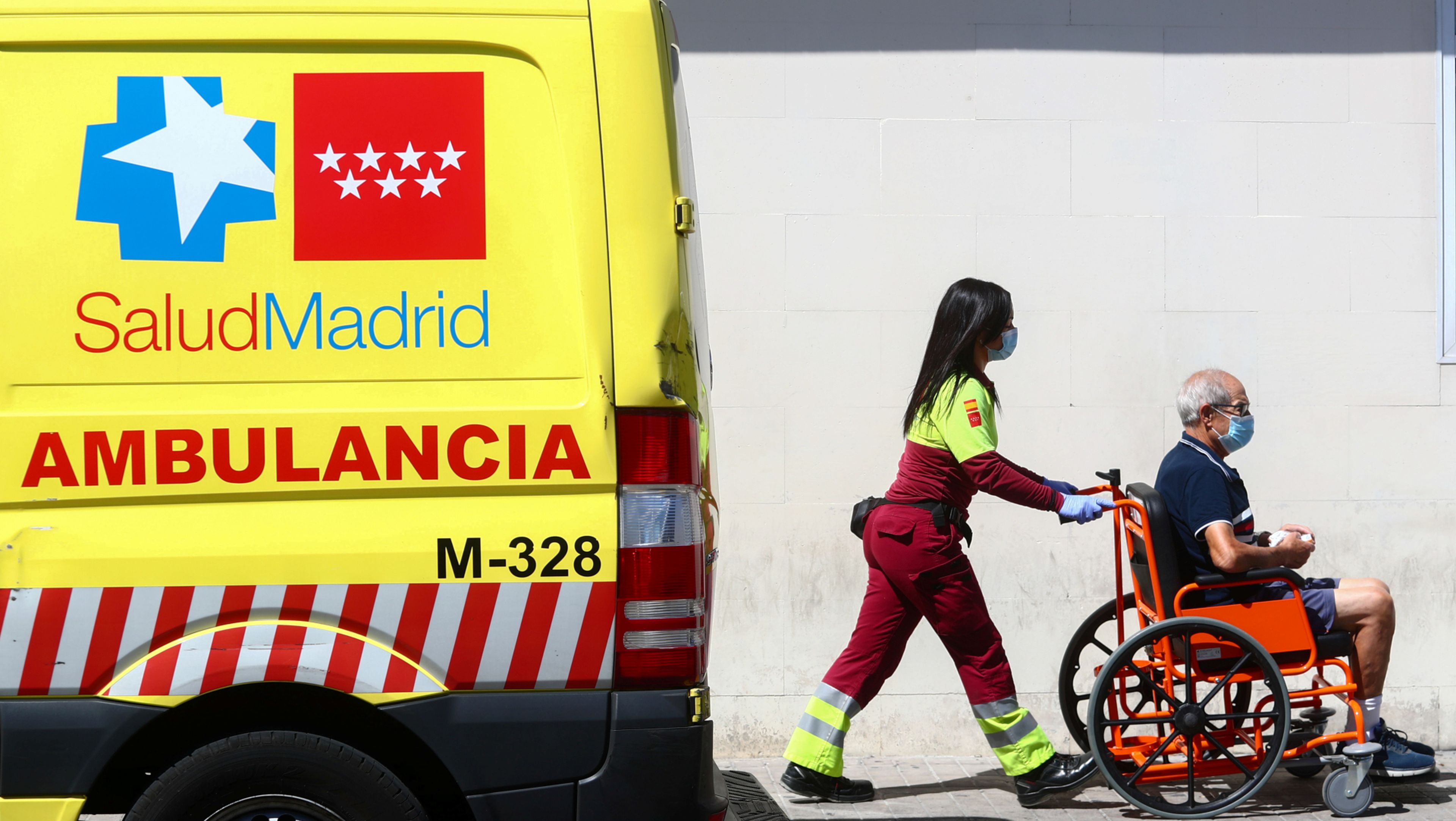 Una trabajadora de la Sanidad madrileña acompaña a un hombre en silla de ruedas al Hospital 12 de Octubre