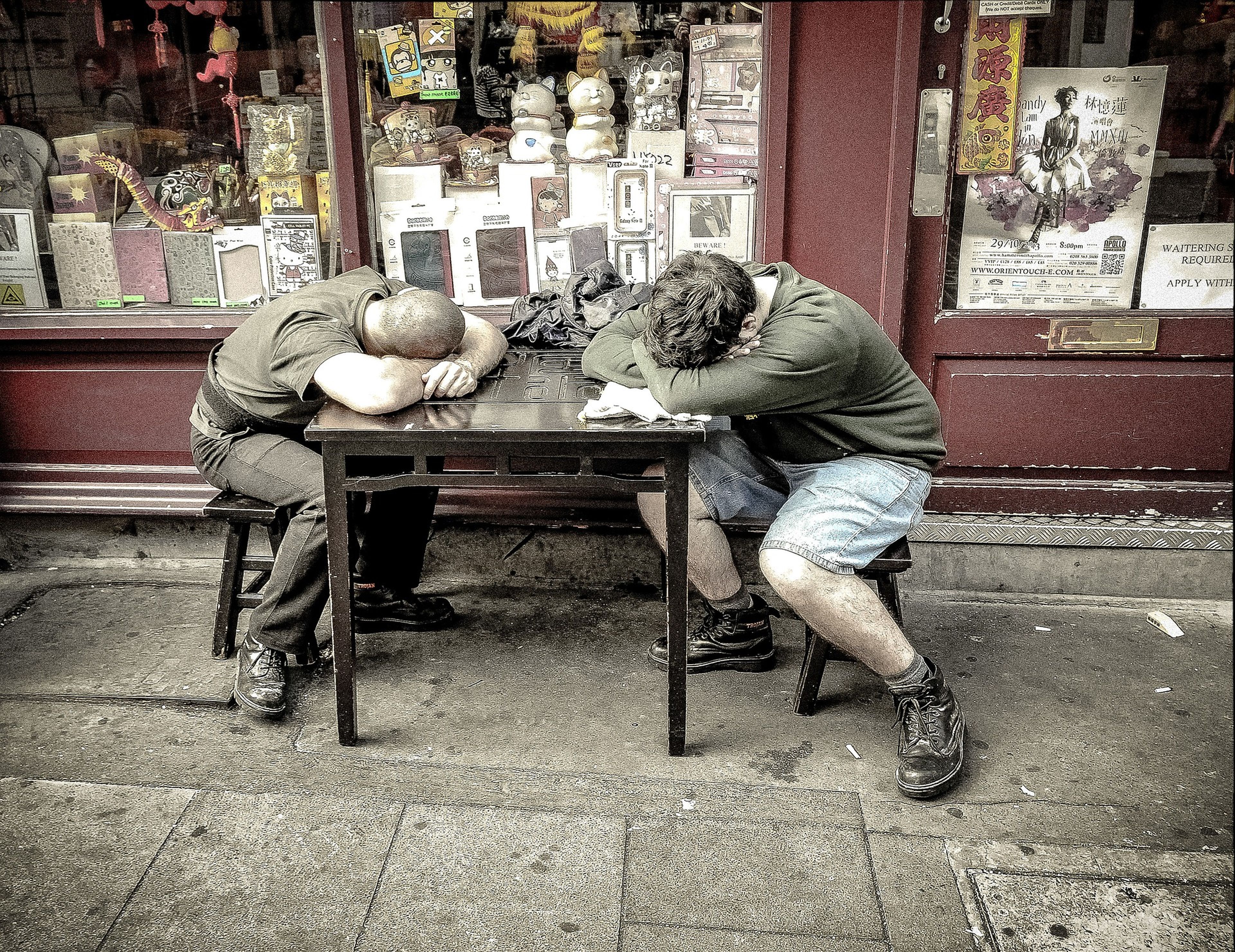 Dos hombres duermen sobre una mesa.