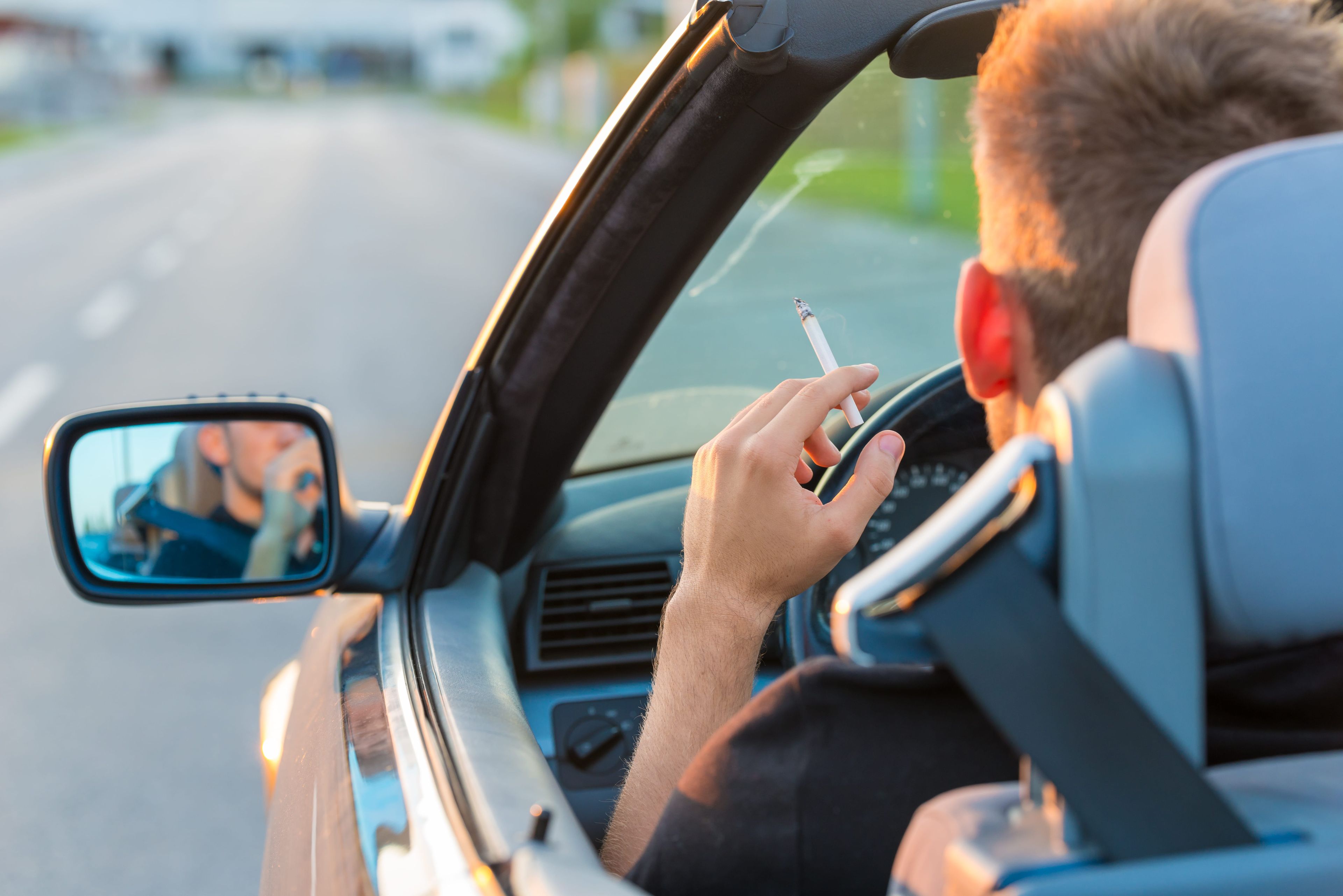 Un hombre fuma mientras conduce