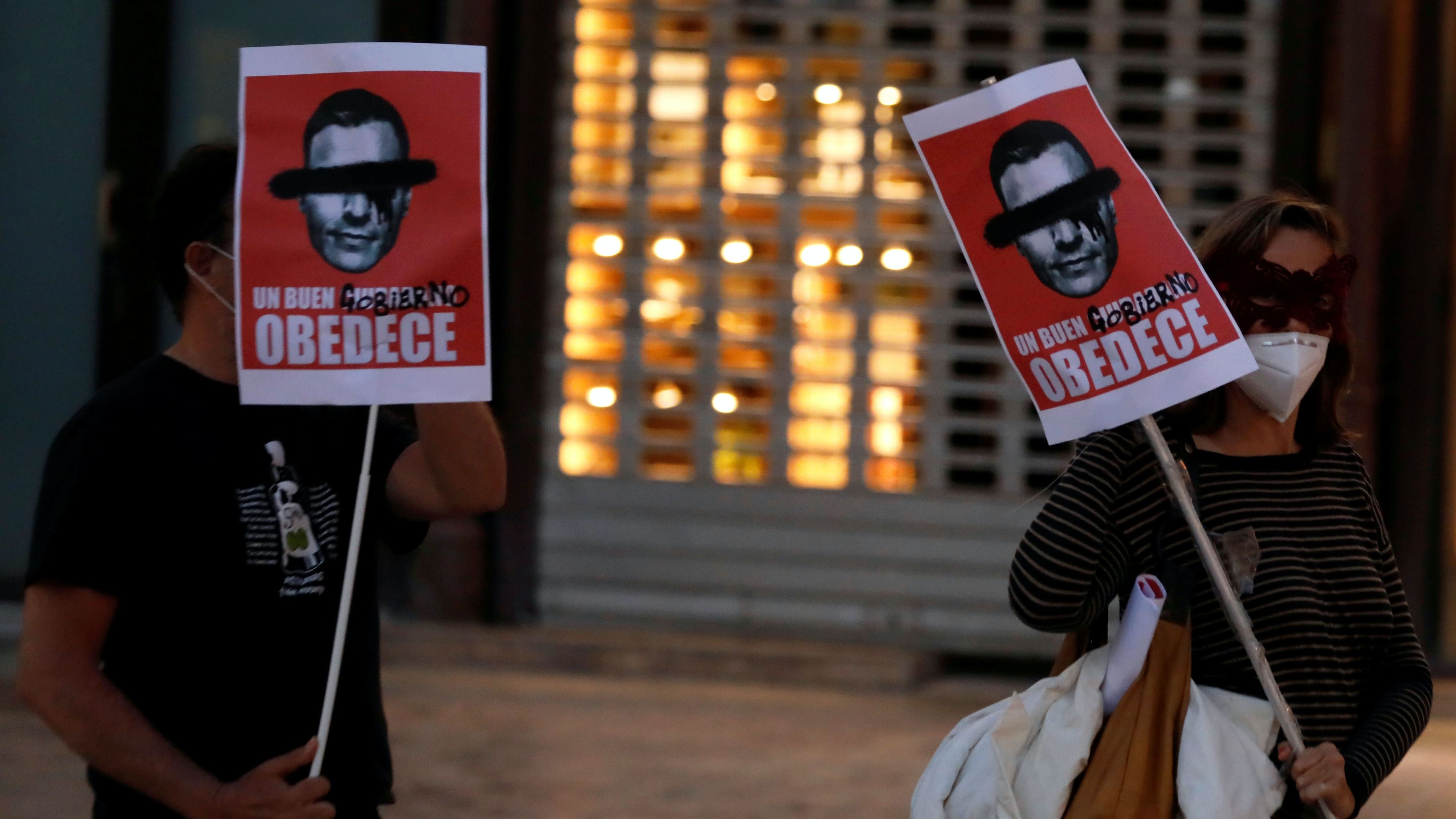 Manifestantes en Málaga llevan los carteles que vende Gobierno Dimisión.