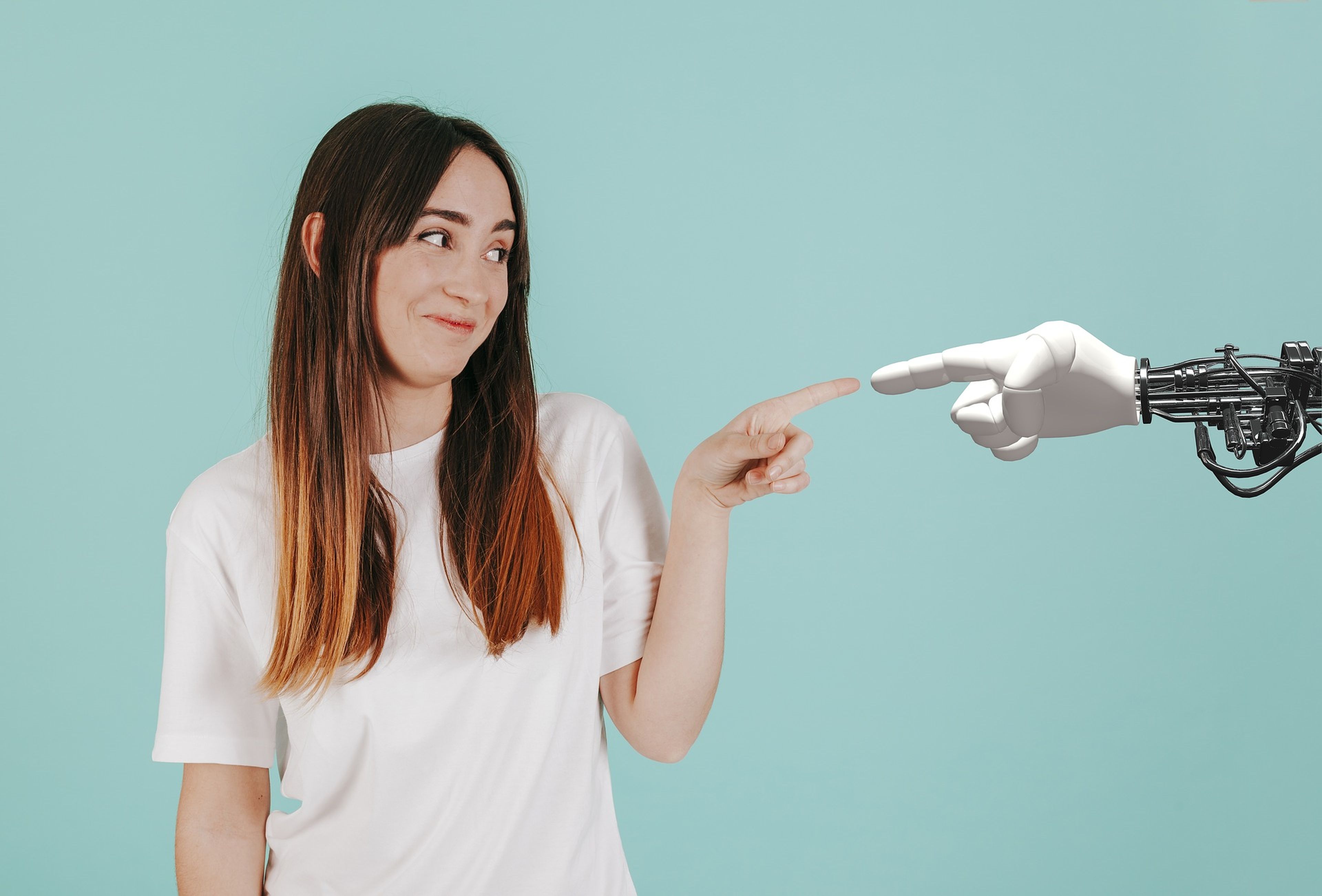 Una mujer choca dedos con un robot.