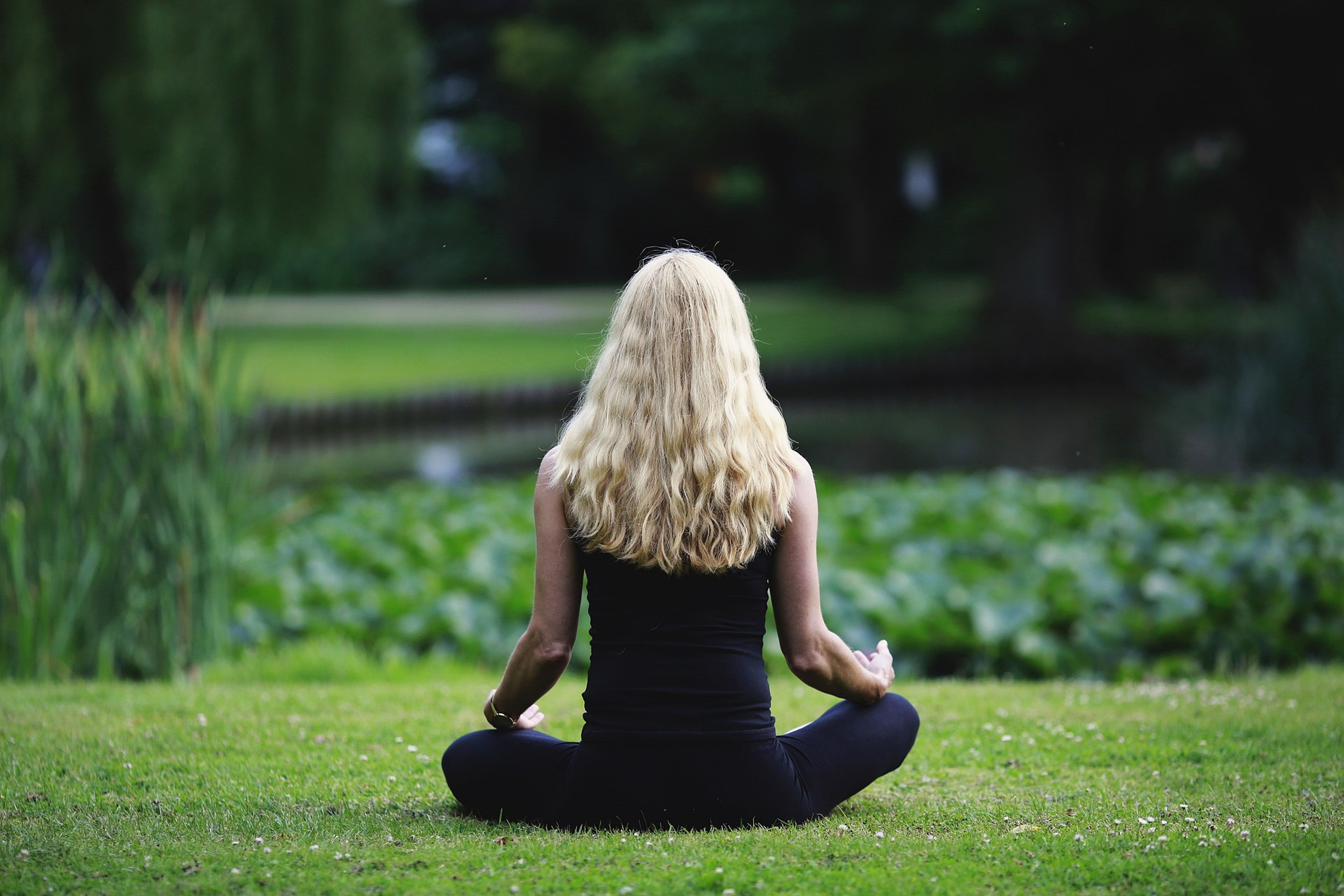 Una mujer medita en plena naturaleza.