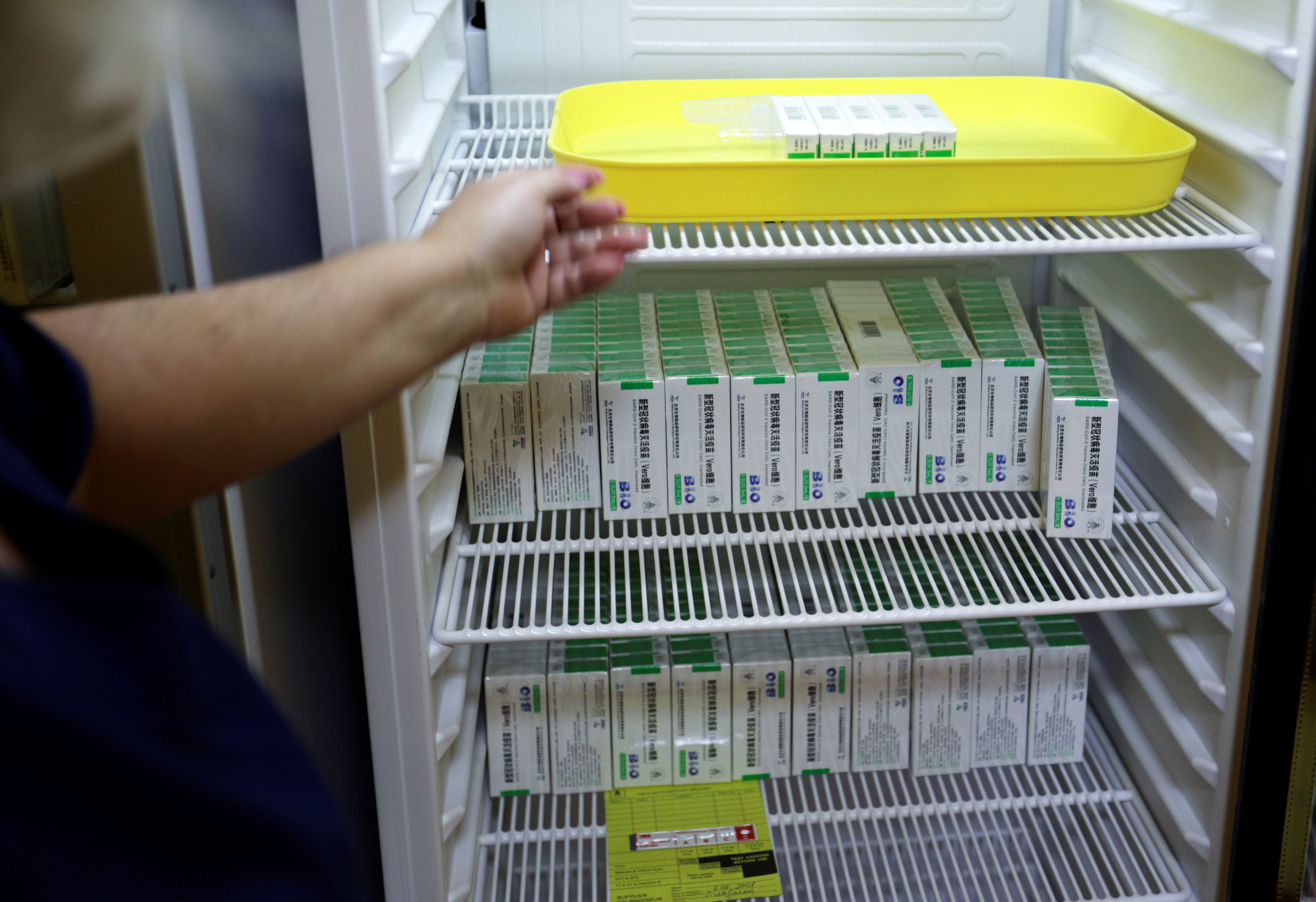 Un trabajador sanitario manipula las vacunas contra el COVID-19 de Sinopharm.