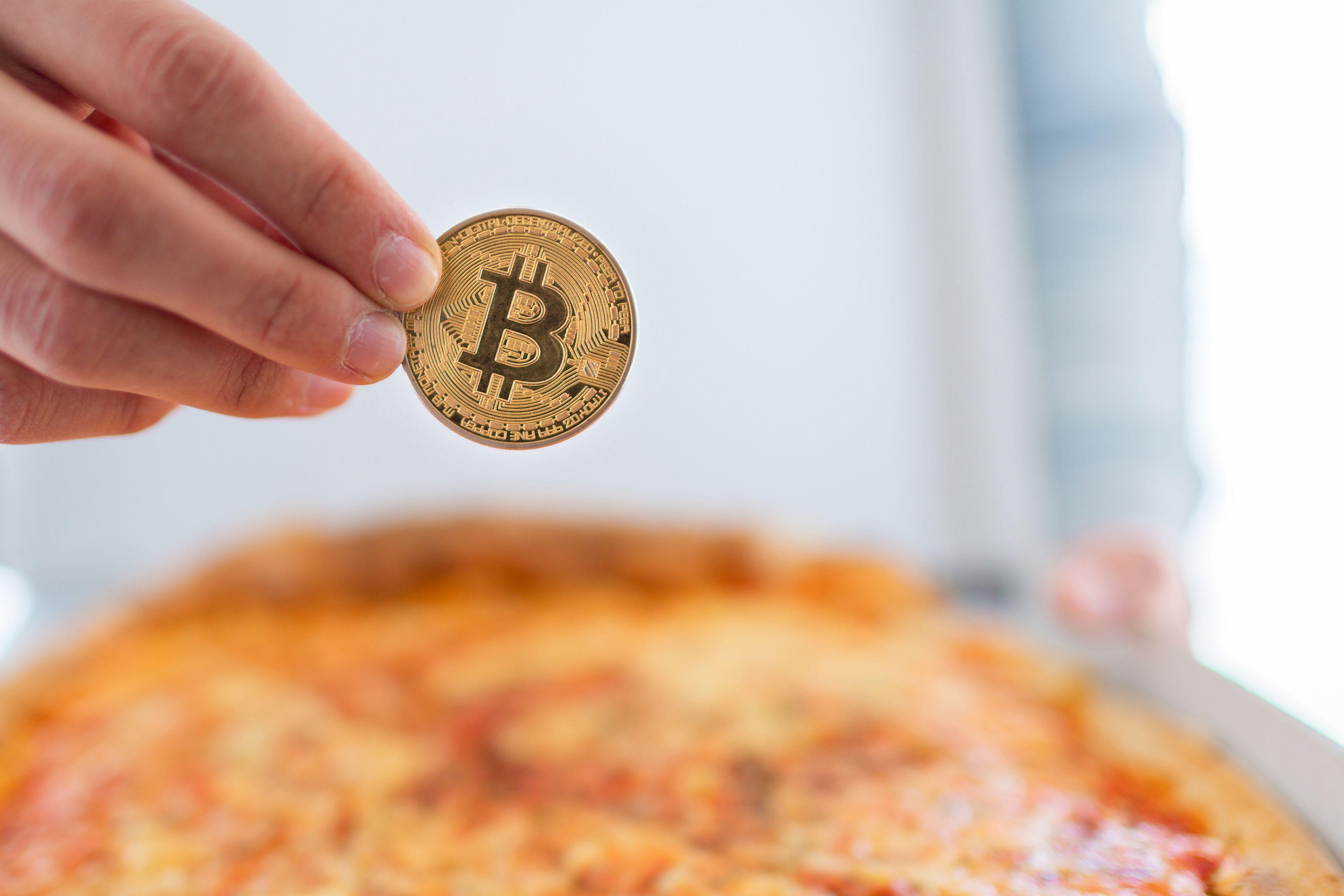 Una persona paga una pizza con bitcoin.