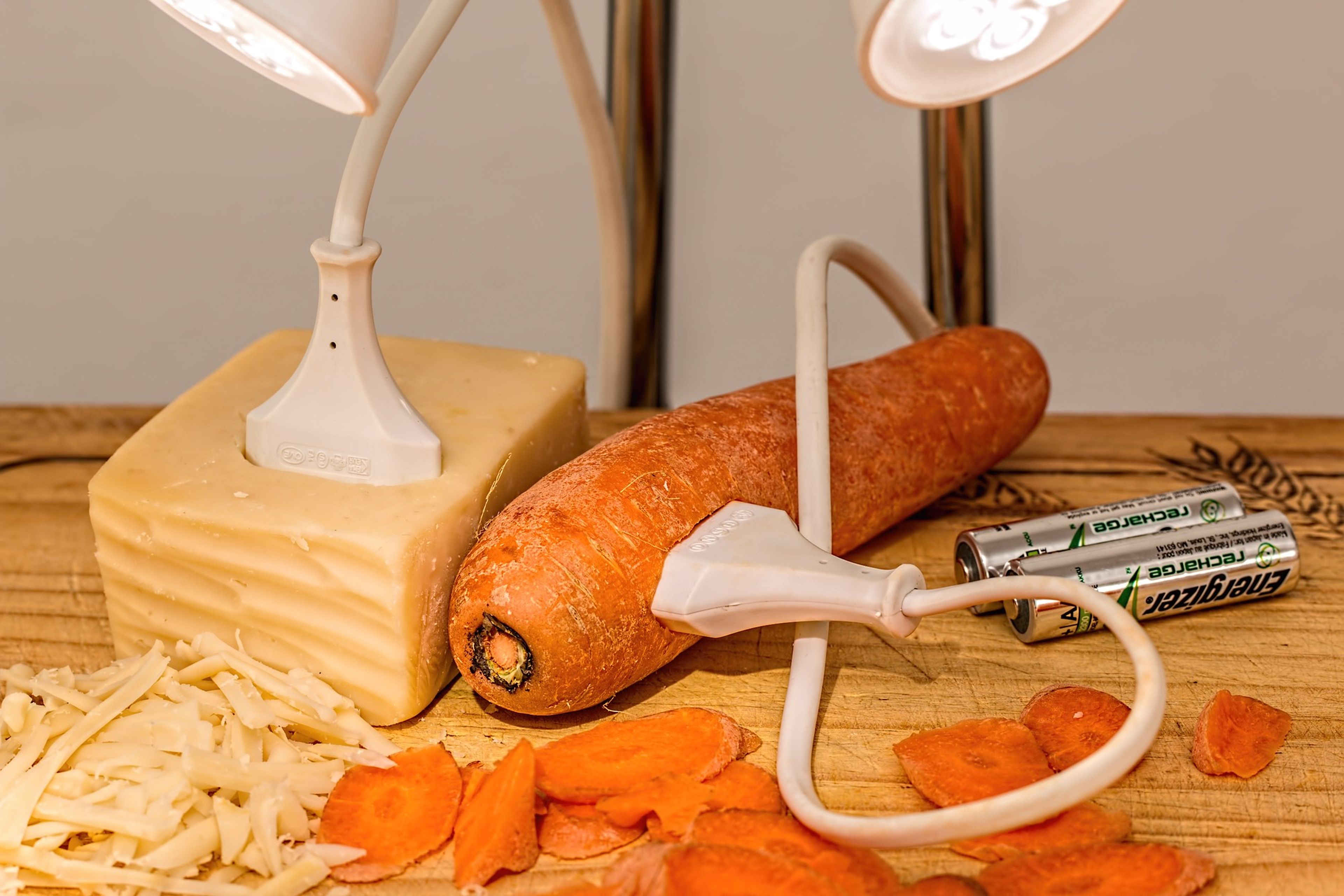 Un cable enchufado en una zanahoria y un queso.